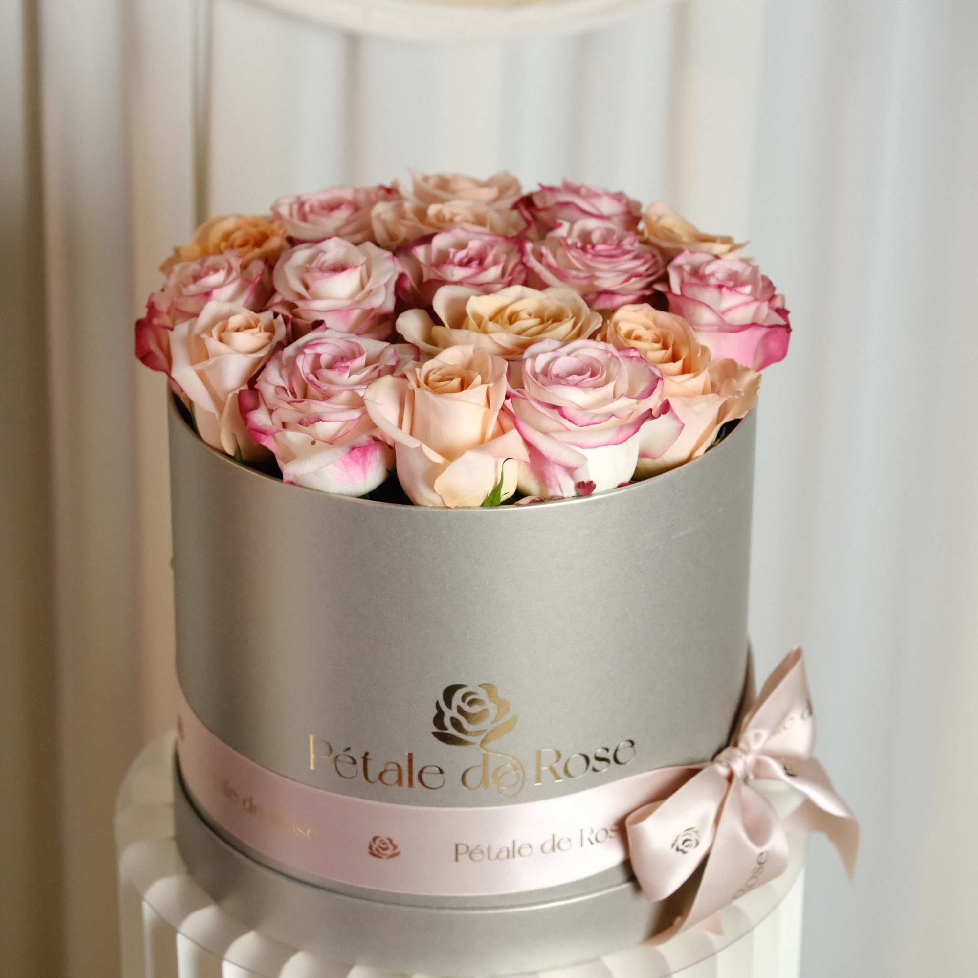 A delicate blend of ivory, and soft pink roses beautifully arranged in