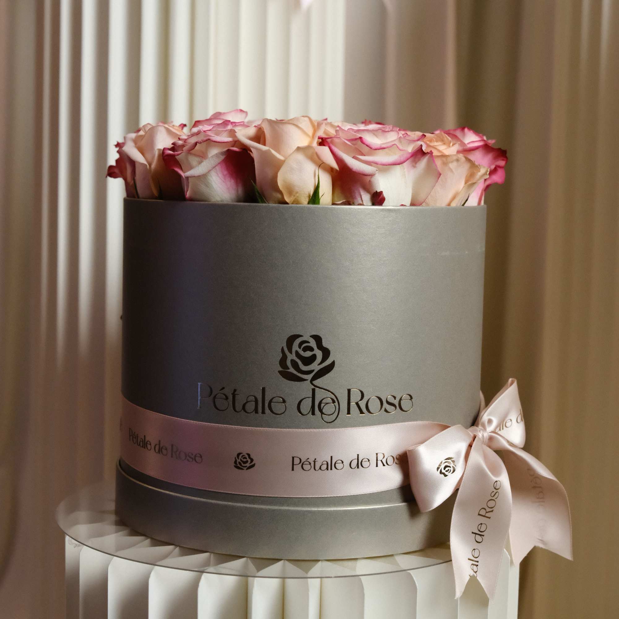 A delicate blend of ivory, and soft pink roses beautifully arranged in