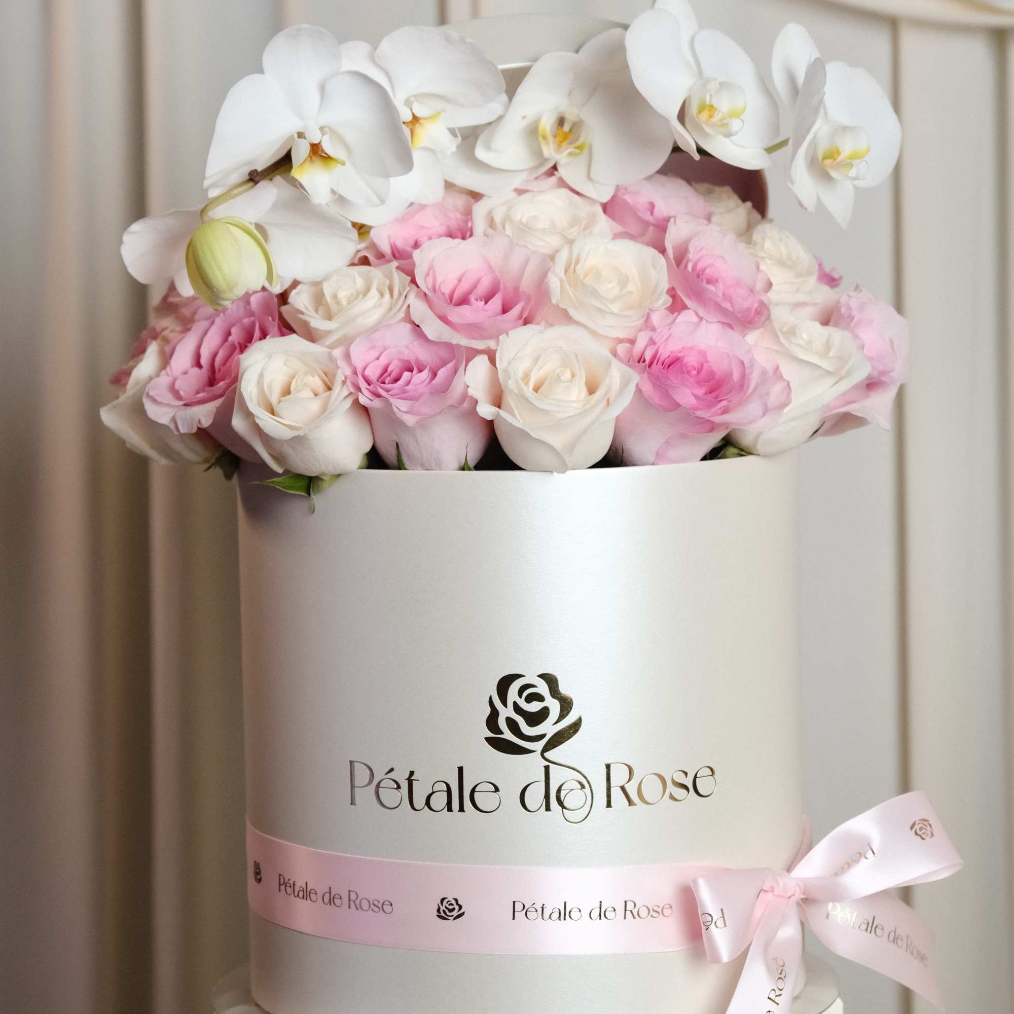 A timeless luxury arrangement featuring blush and ivory roses topped with elegant