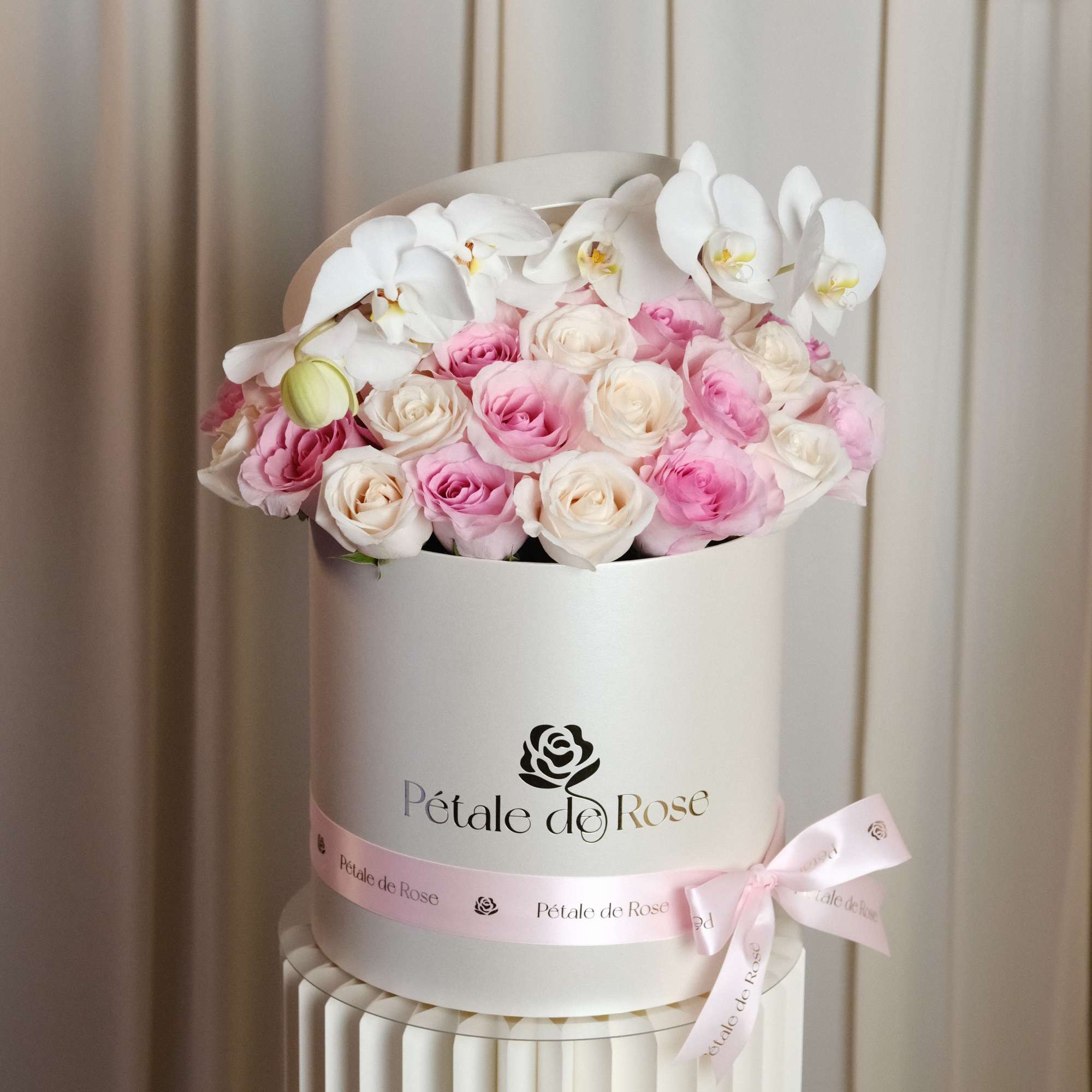 A timeless luxury arrangement featuring blush and ivory roses topped with elegant