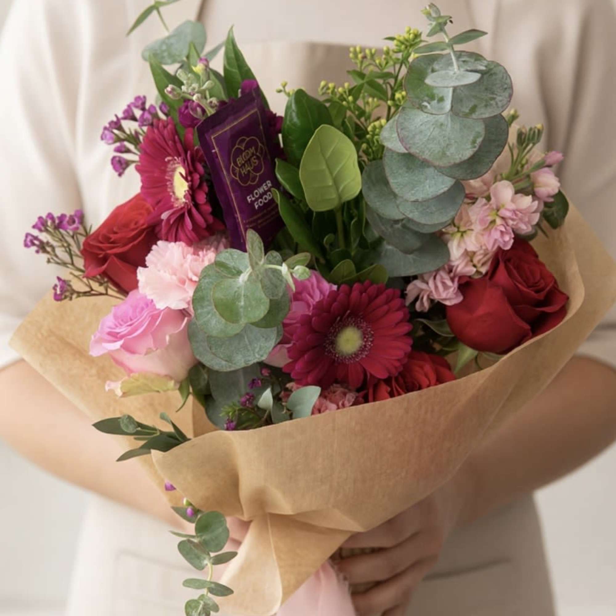 A soft and romantic hand-tied bouquet designed with fresh seasonal blooms in