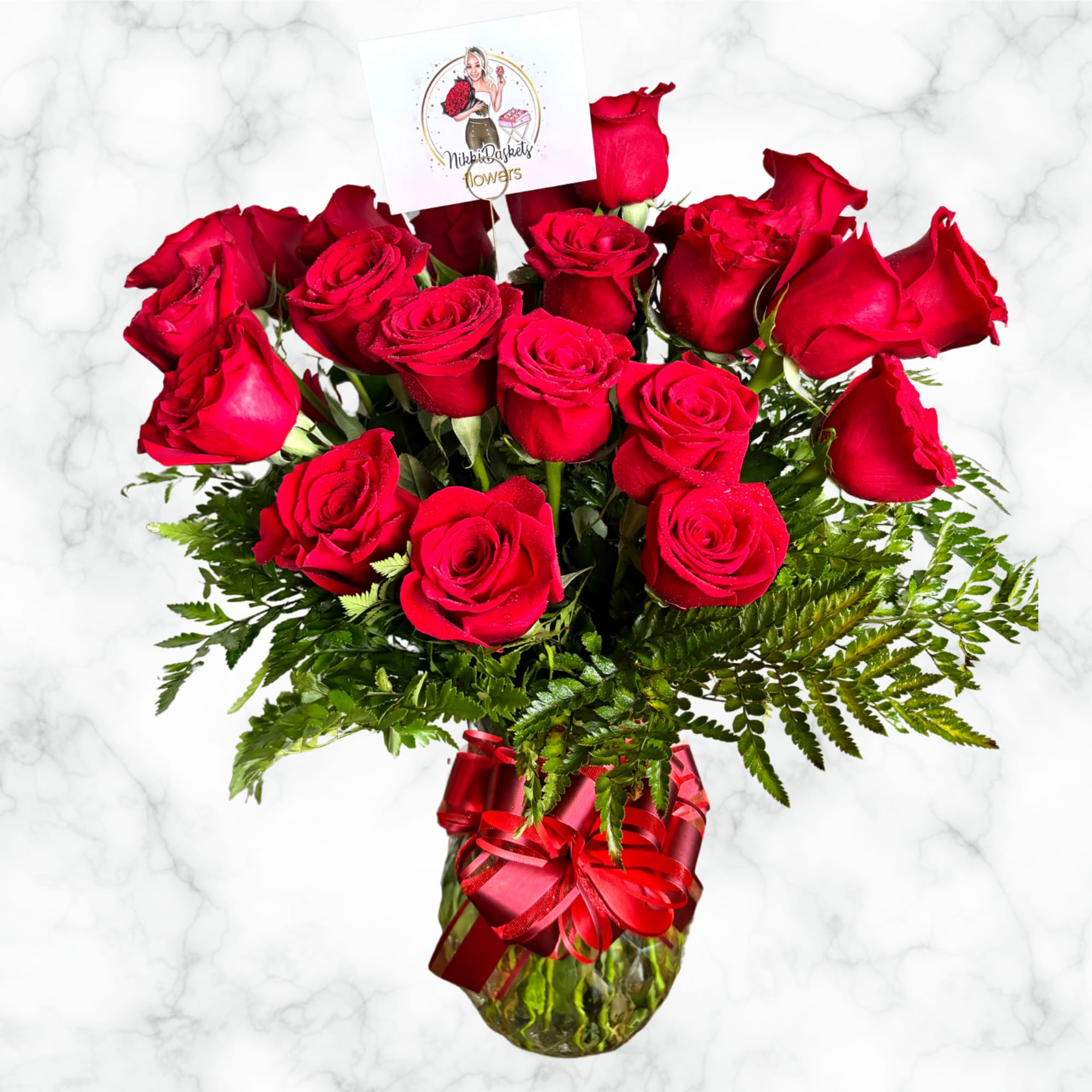 Bouquet of red roses in a glass vase with a red ribbon