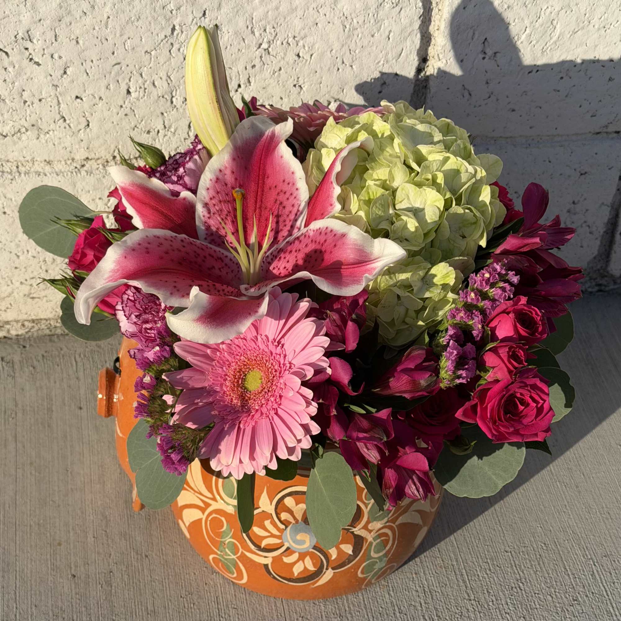 Bright sunflowers and soft pink lilies make an immediate cheerful impression in