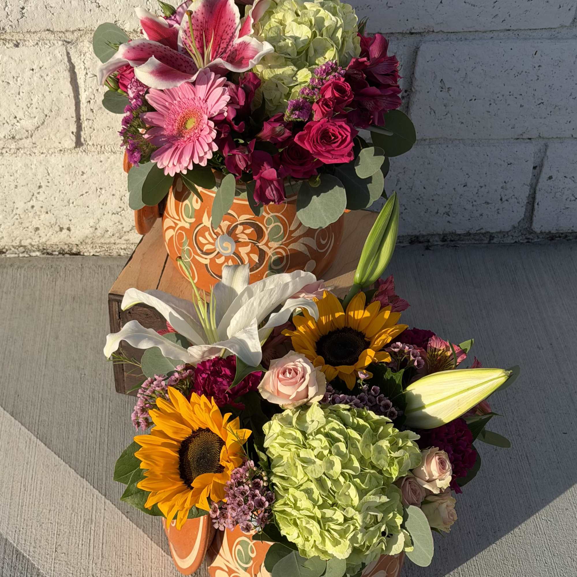 Bright sunflowers and soft pink lilies make an immediate cheerful impression in