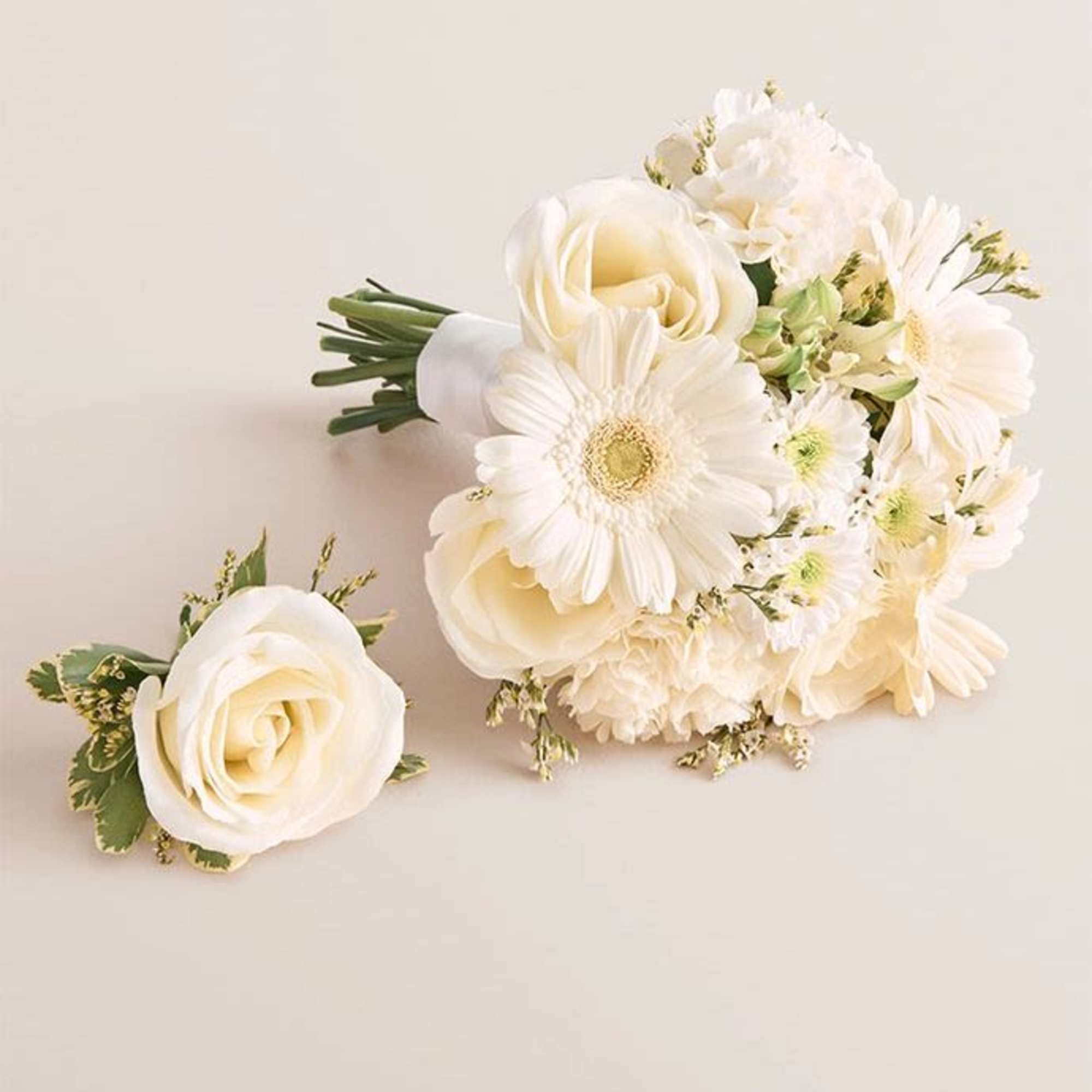 Creamy ivory roses and open white gerbera daisies give this junior bouquet