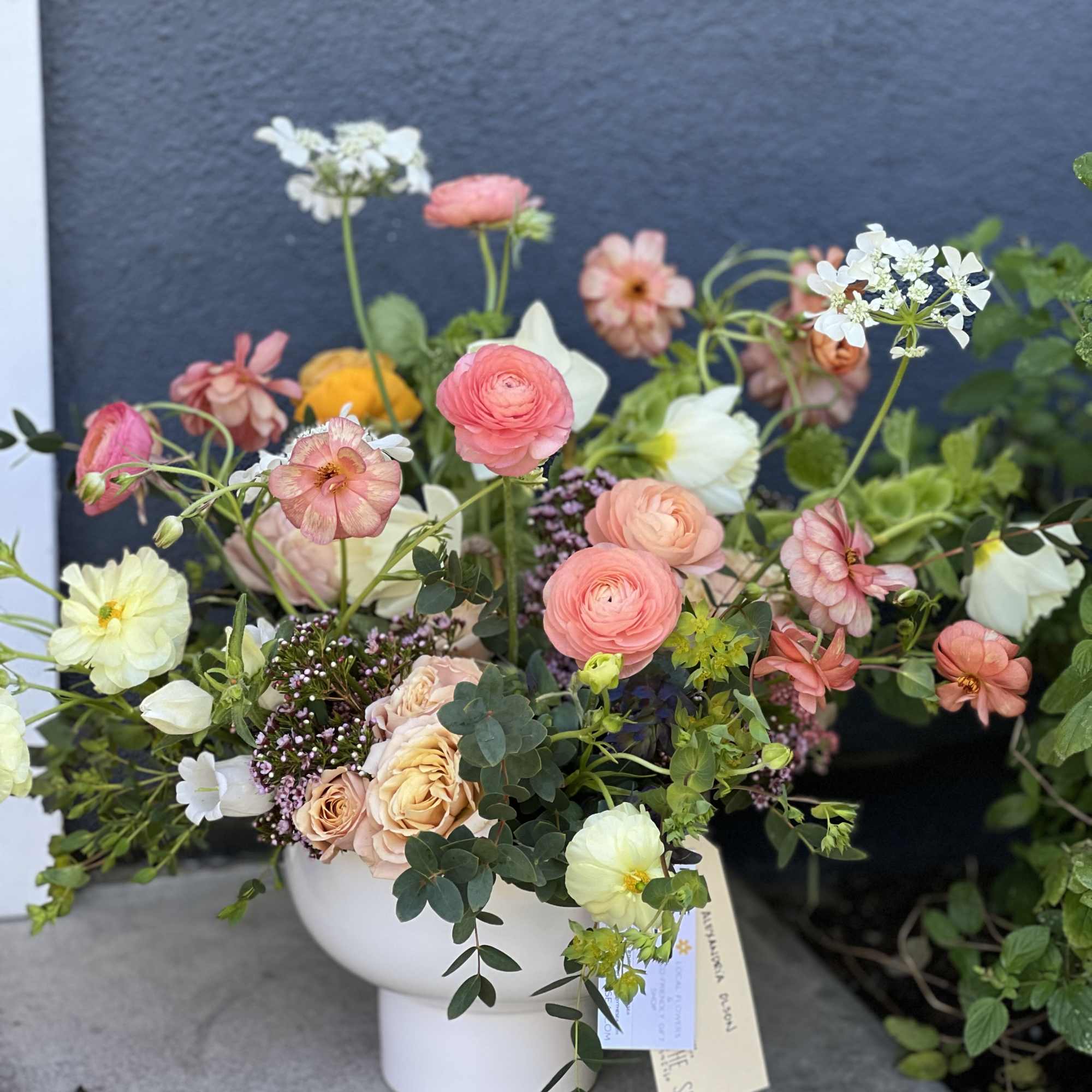 Mixed pastel bouquet in a white vase with pink and white blooms