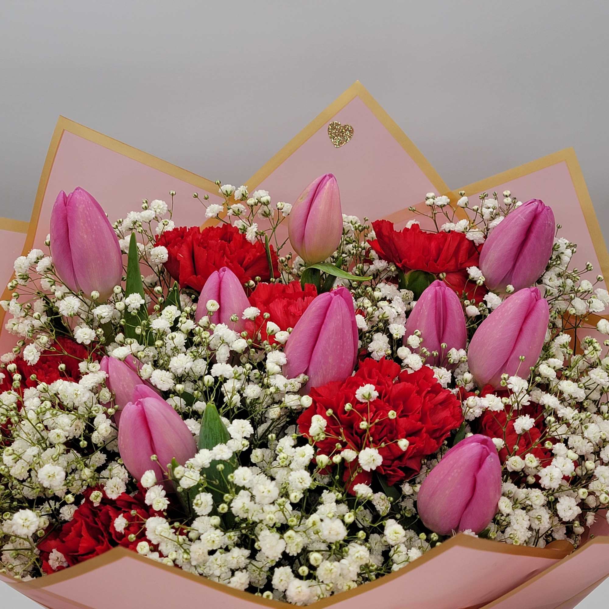 Bouquet of pink tulips, red carnations, and white baby's breath
