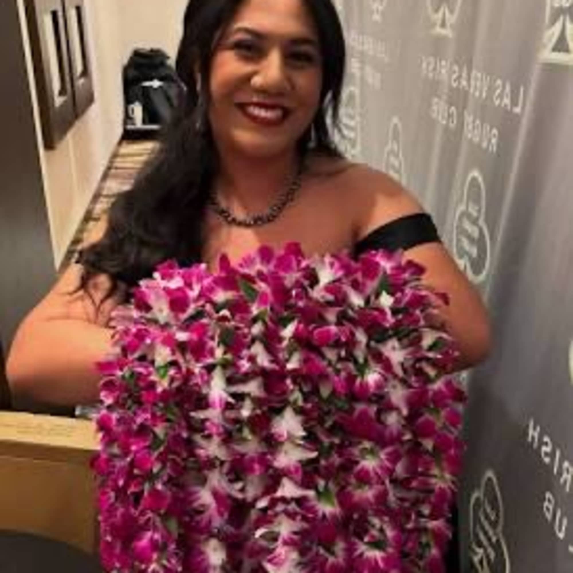 Woman holding a large pink-and-white flower lei