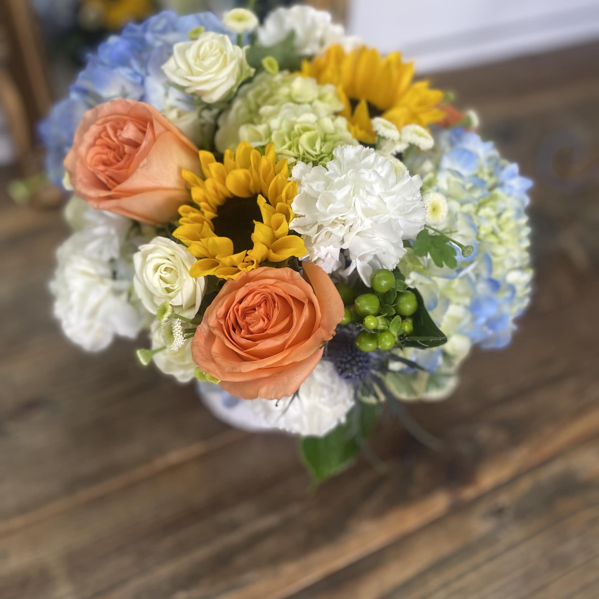 Bouquet of roses, sunflowers, hydrangeas, and white carnations