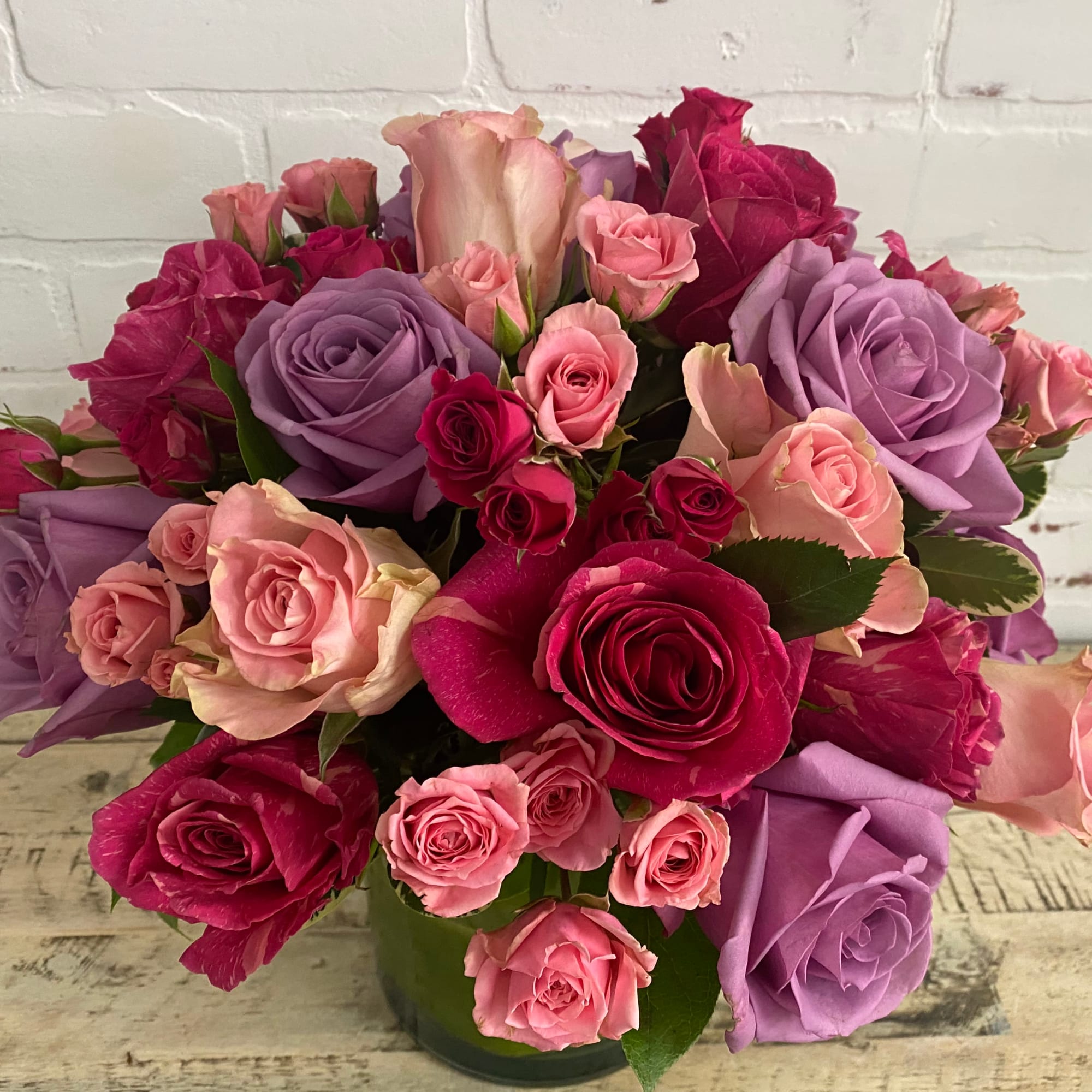 Bouquet of pink and lavender roses in a glass vase