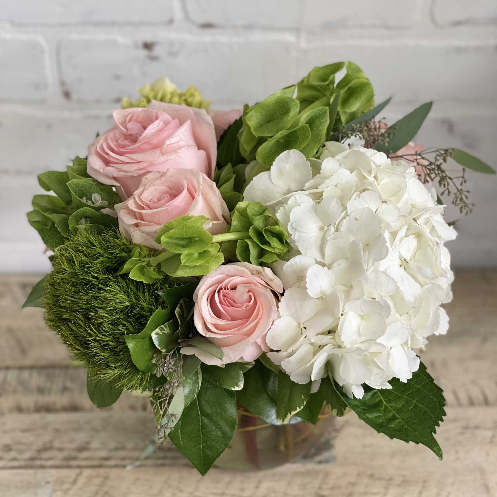 Pink roses and white hydrangea in a glass vase