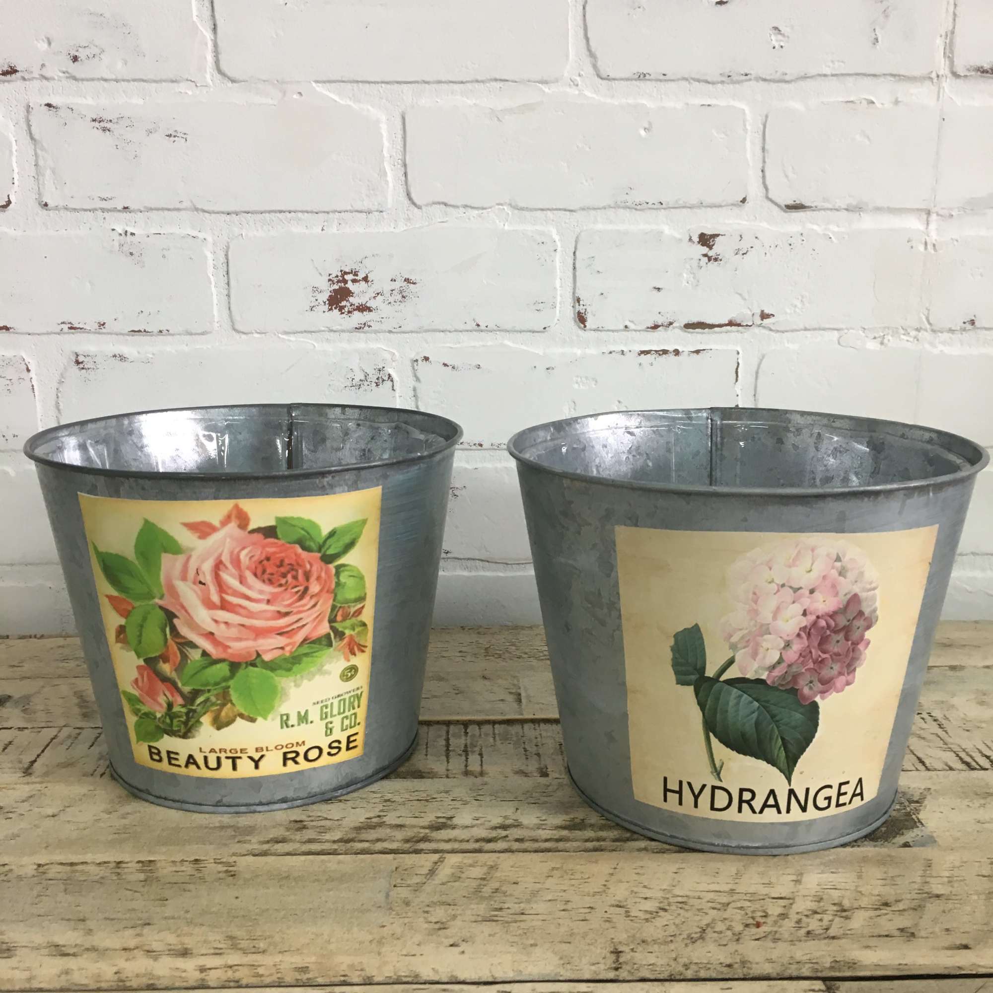 Two metal buckets with rose and hydrangea labels
