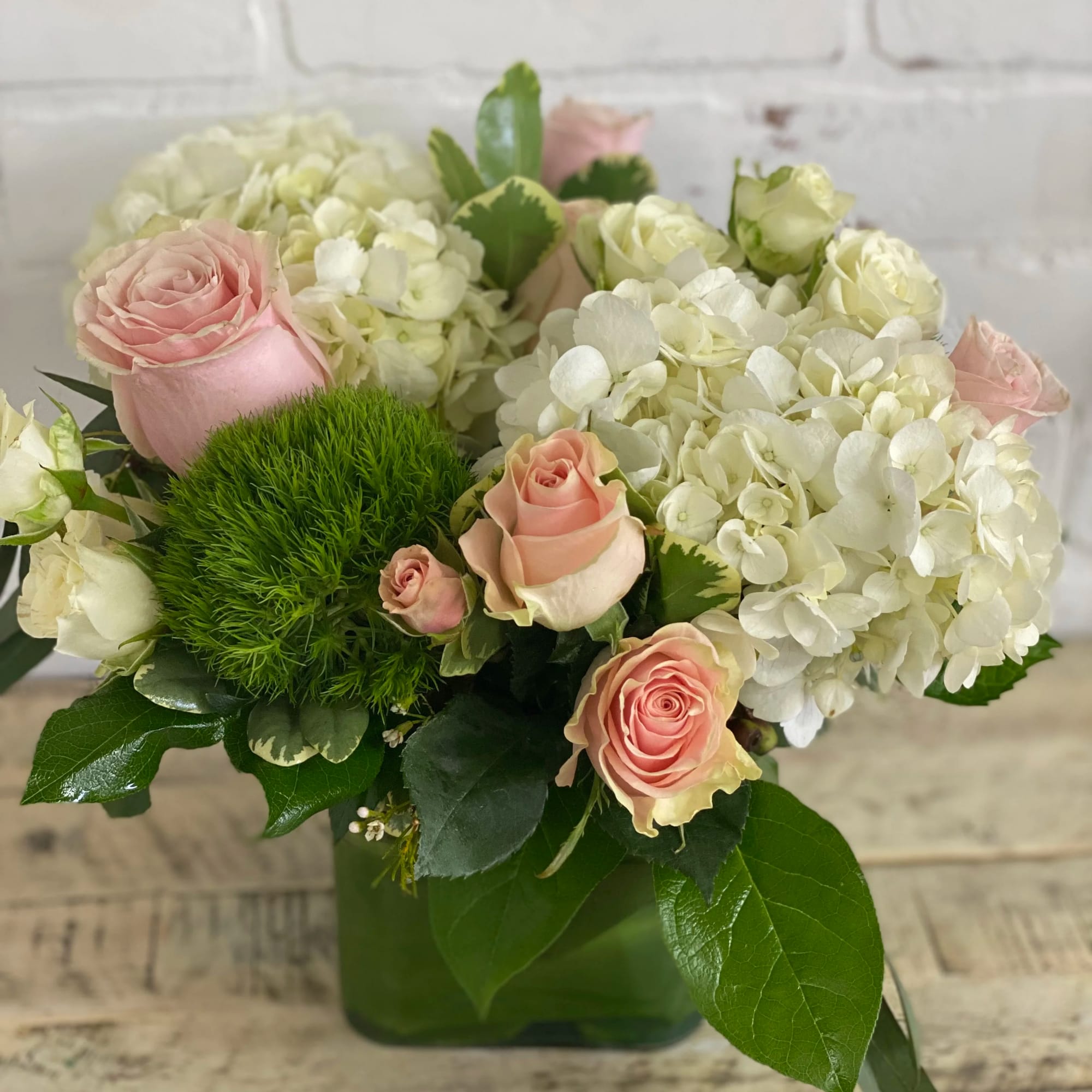 Pink roses and white hydrangeas in a green vase