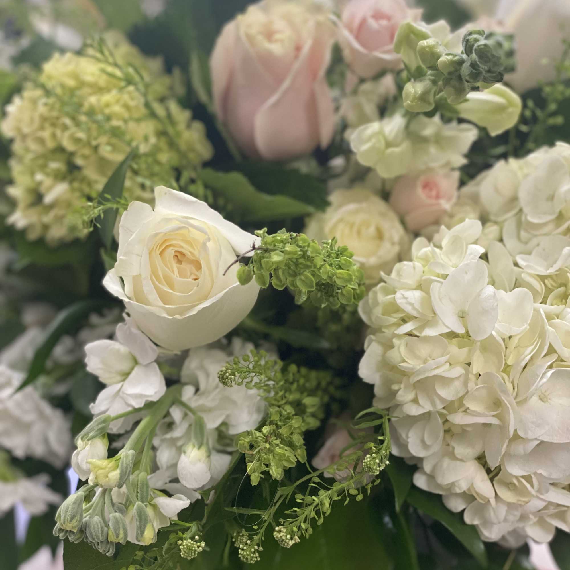 Bouquet of white and blush roses with white hydrangea and green accents
