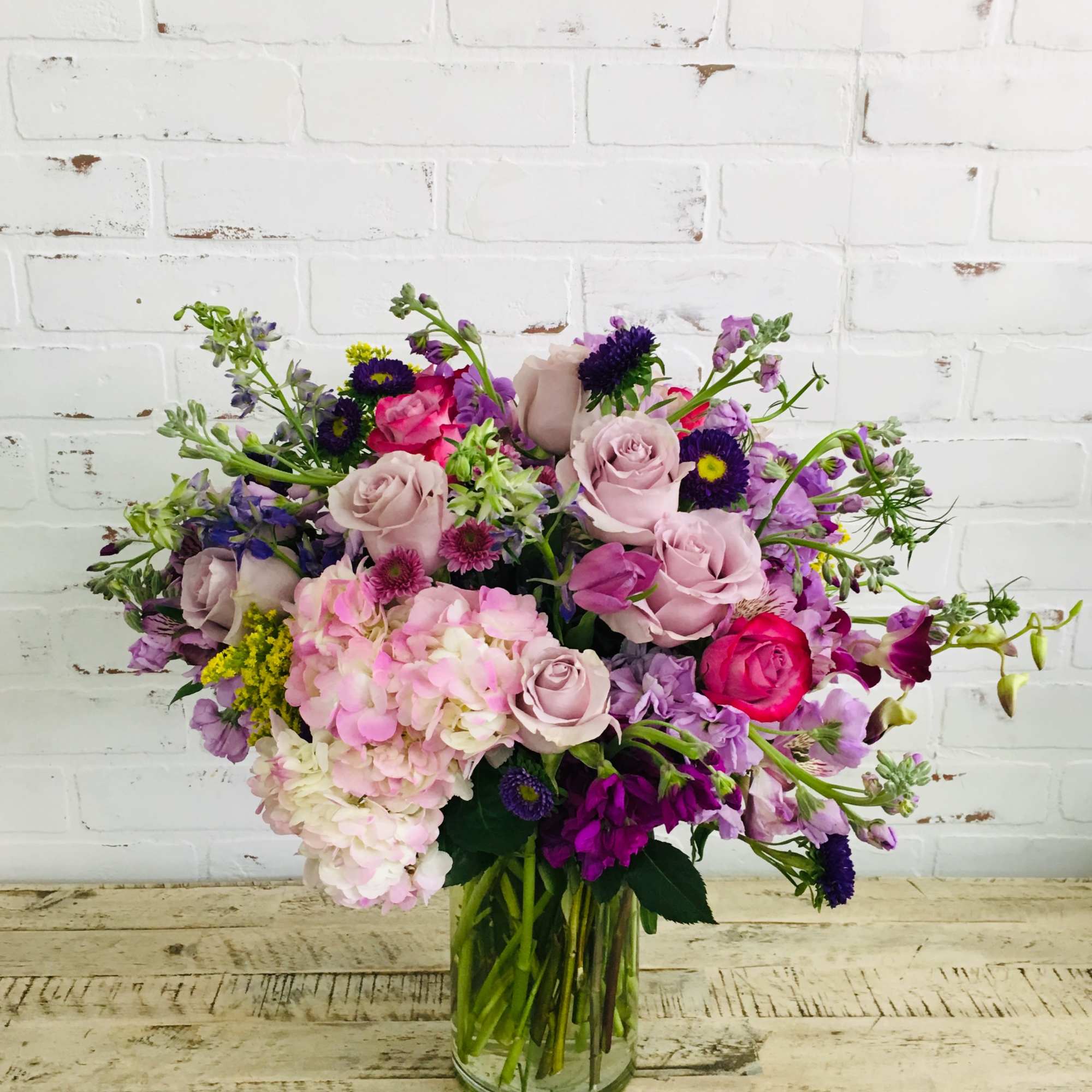 Mixed pink and purple bouquet in a clear glass vase