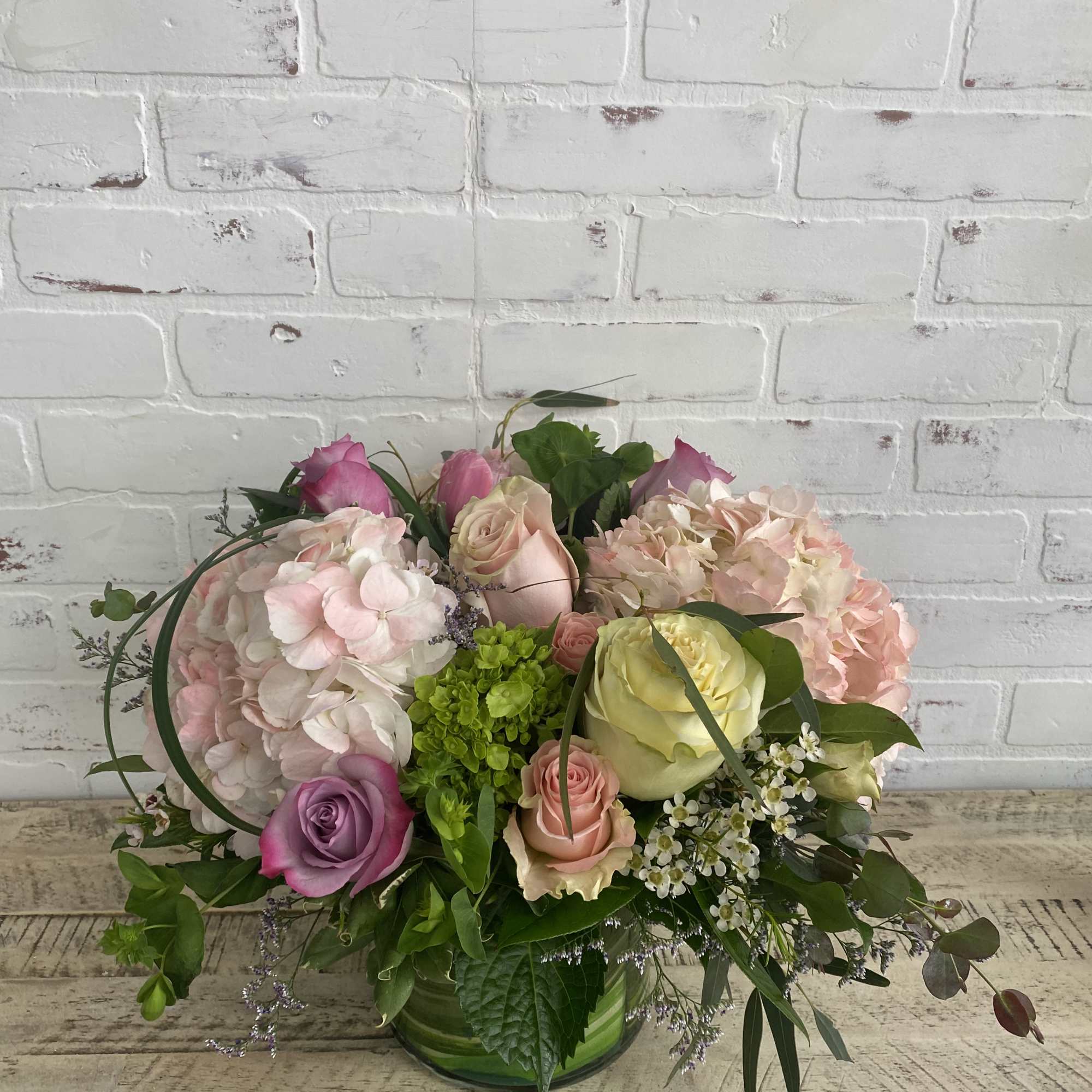 Light colored blooms of soft pinks, whites, green, and touches of purple.