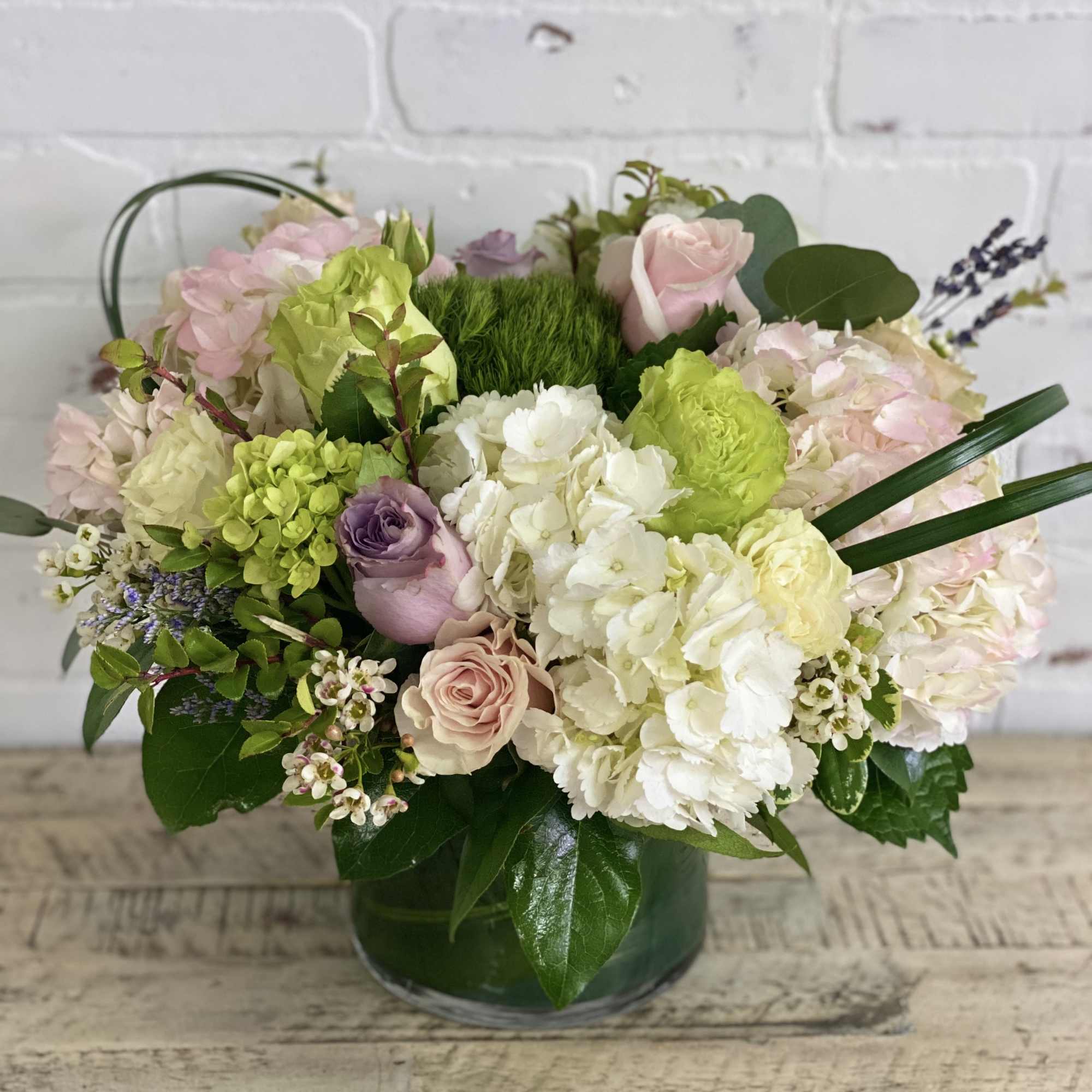 Light colored blooms of soft pinks, whites, green, and touches of purple.