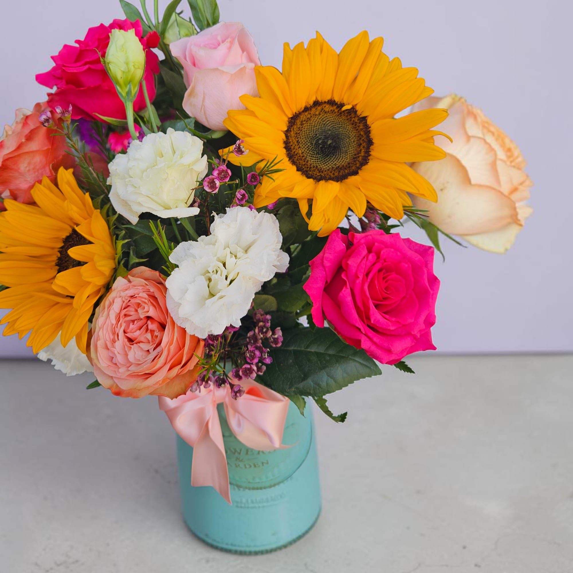Bright yellow sunflowers burst from a compact, rounded flower arrangement that feels