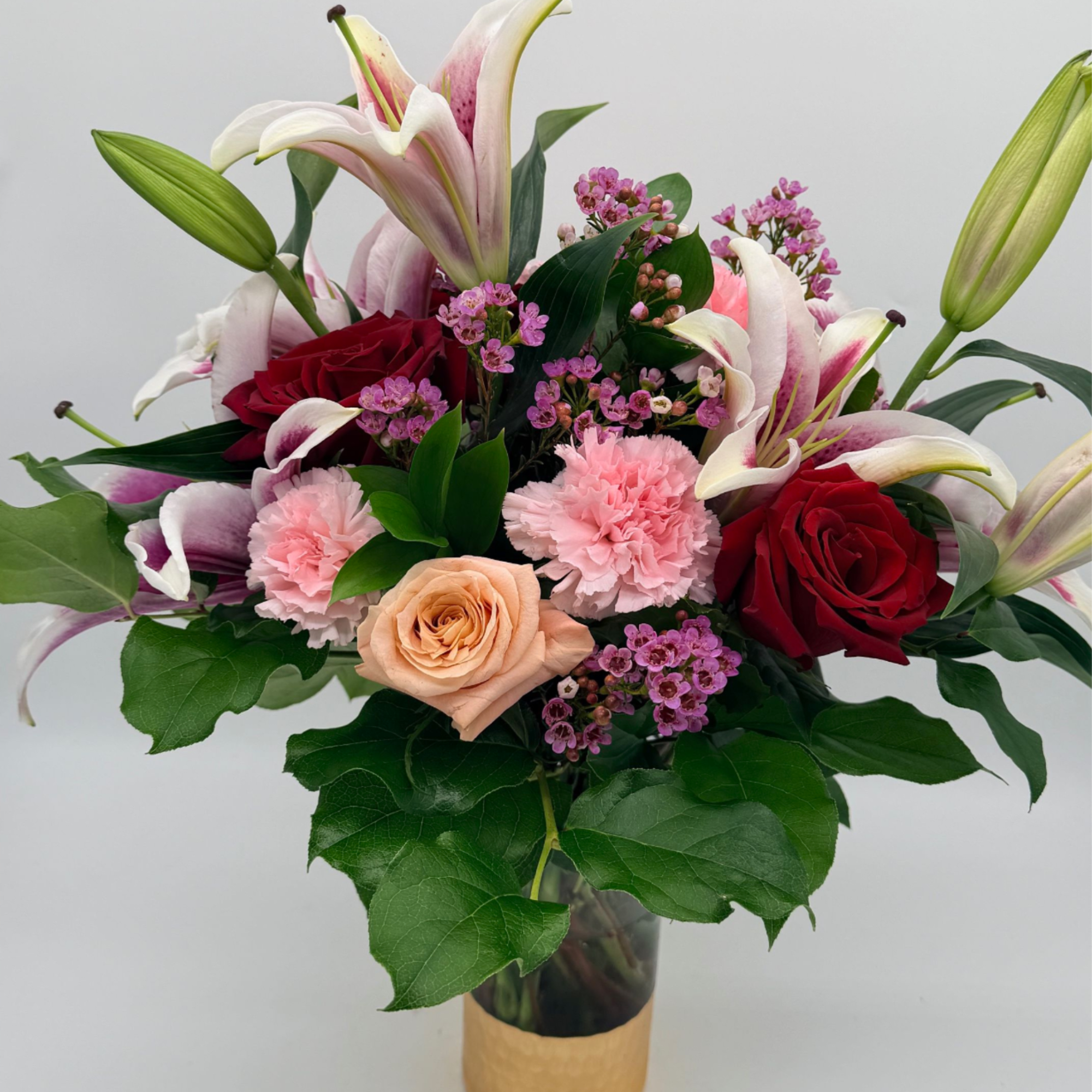A swoon-worthy arrangement that speaks the language of love, roses, lilies, and