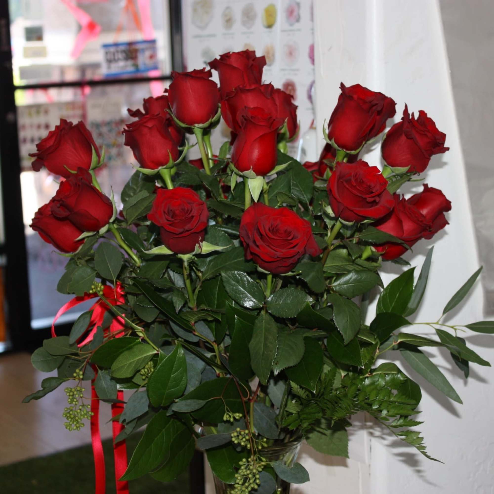 Bouquet of red roses with greenery and a red ribbon