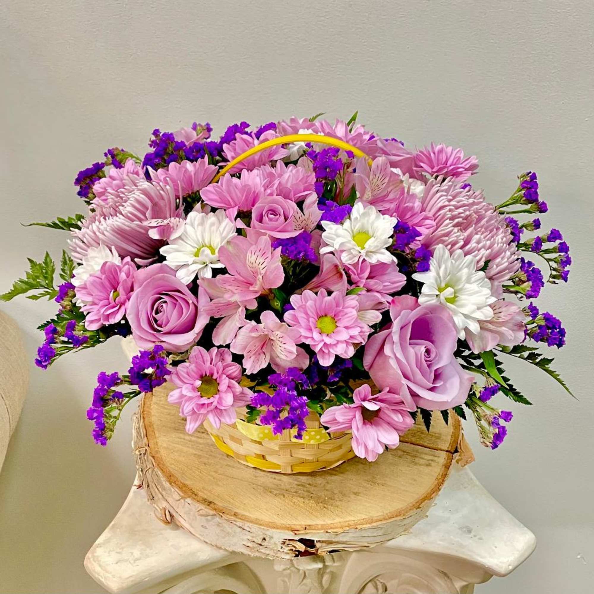 Pink and purple flower basket with roses and daisies