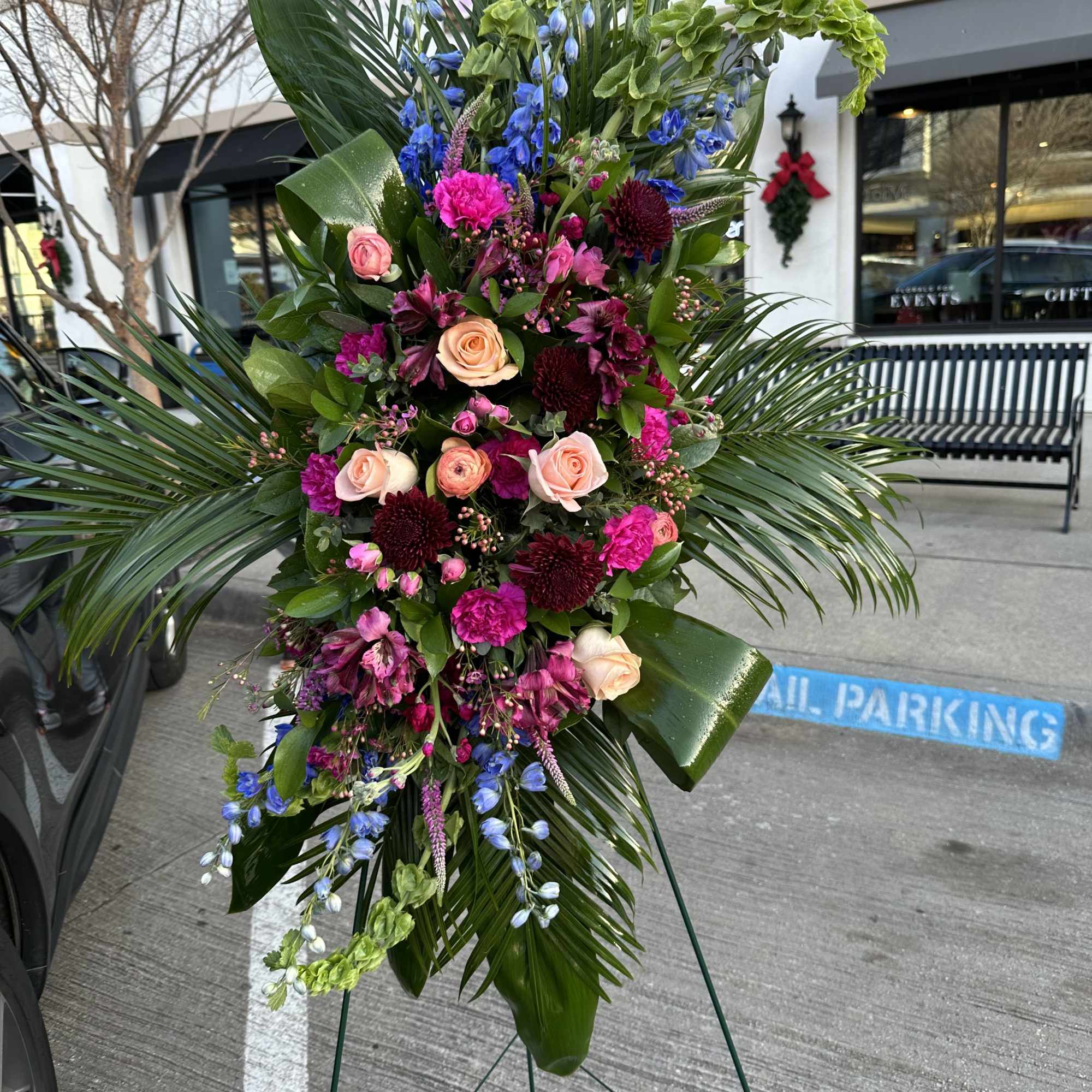 Tall standing floral spray with pink roses and blue flowers