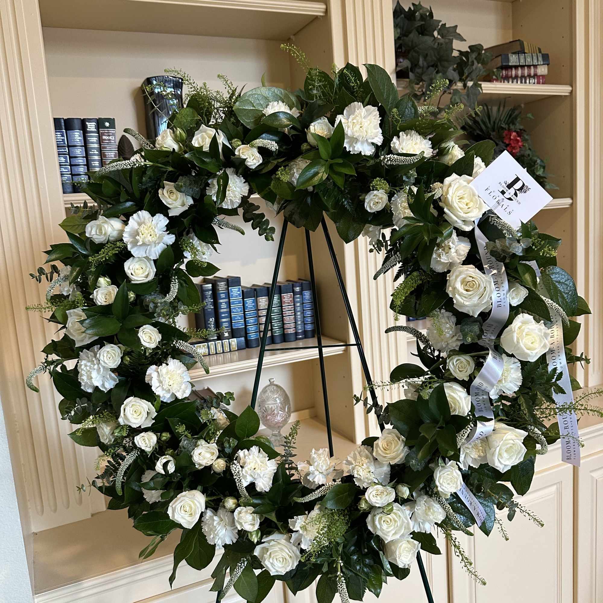 White rose and carnation wreath on a stand