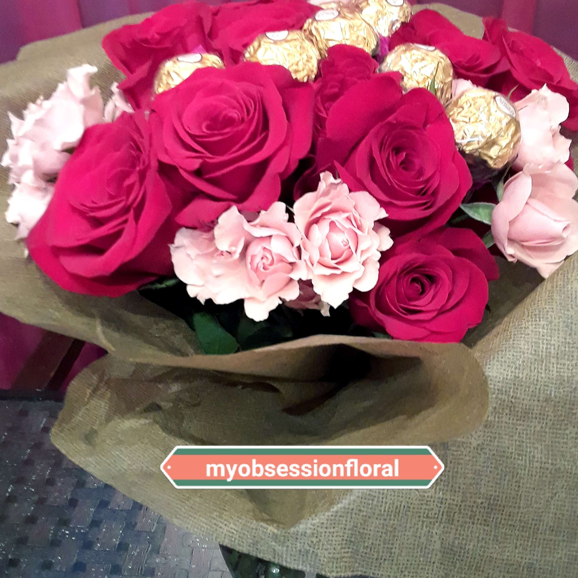 Bouquet of hot pink and pale pink roses with gold-wrapped chocolates