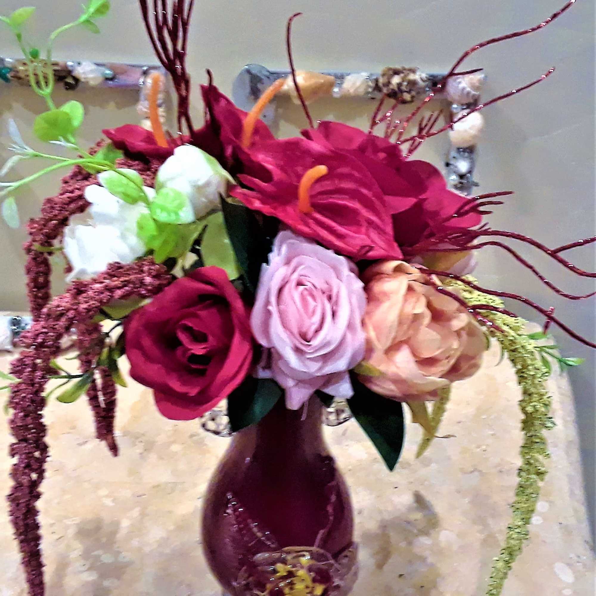 Bouquet of pink, lavender, and peach roses in a purple vase