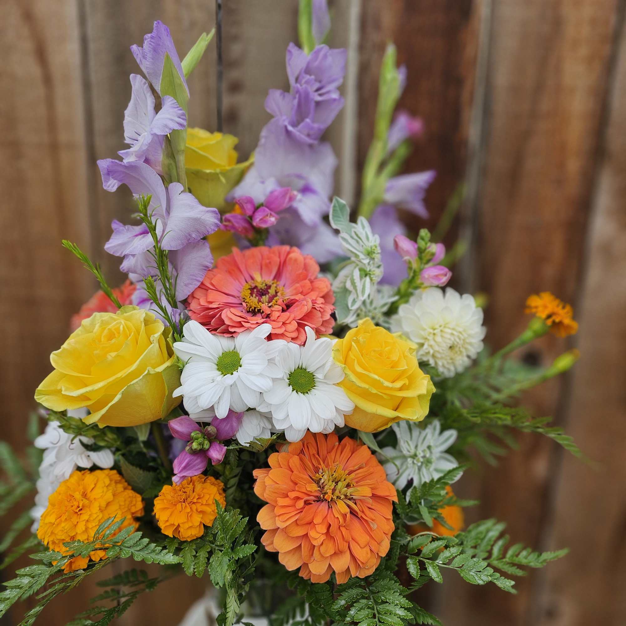 Mixed bouquet with yellow roses, white daisies, and orange blooms