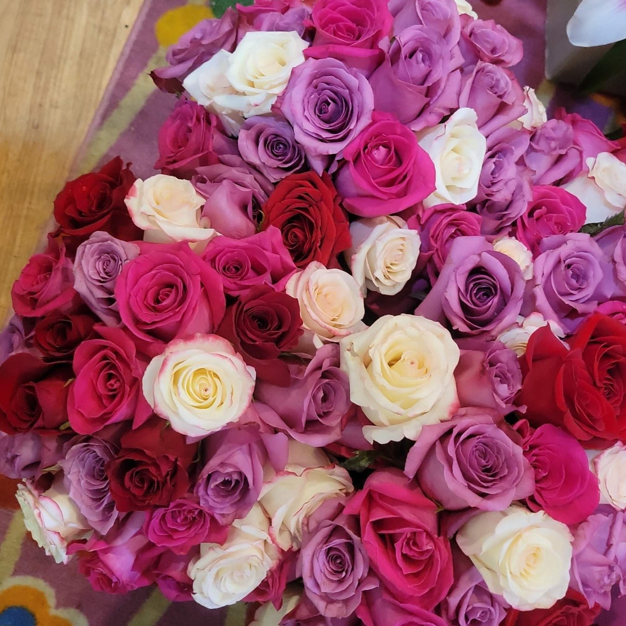Roses, lilies, carnations, and alstroemeria in pinks, purples, red, and white a