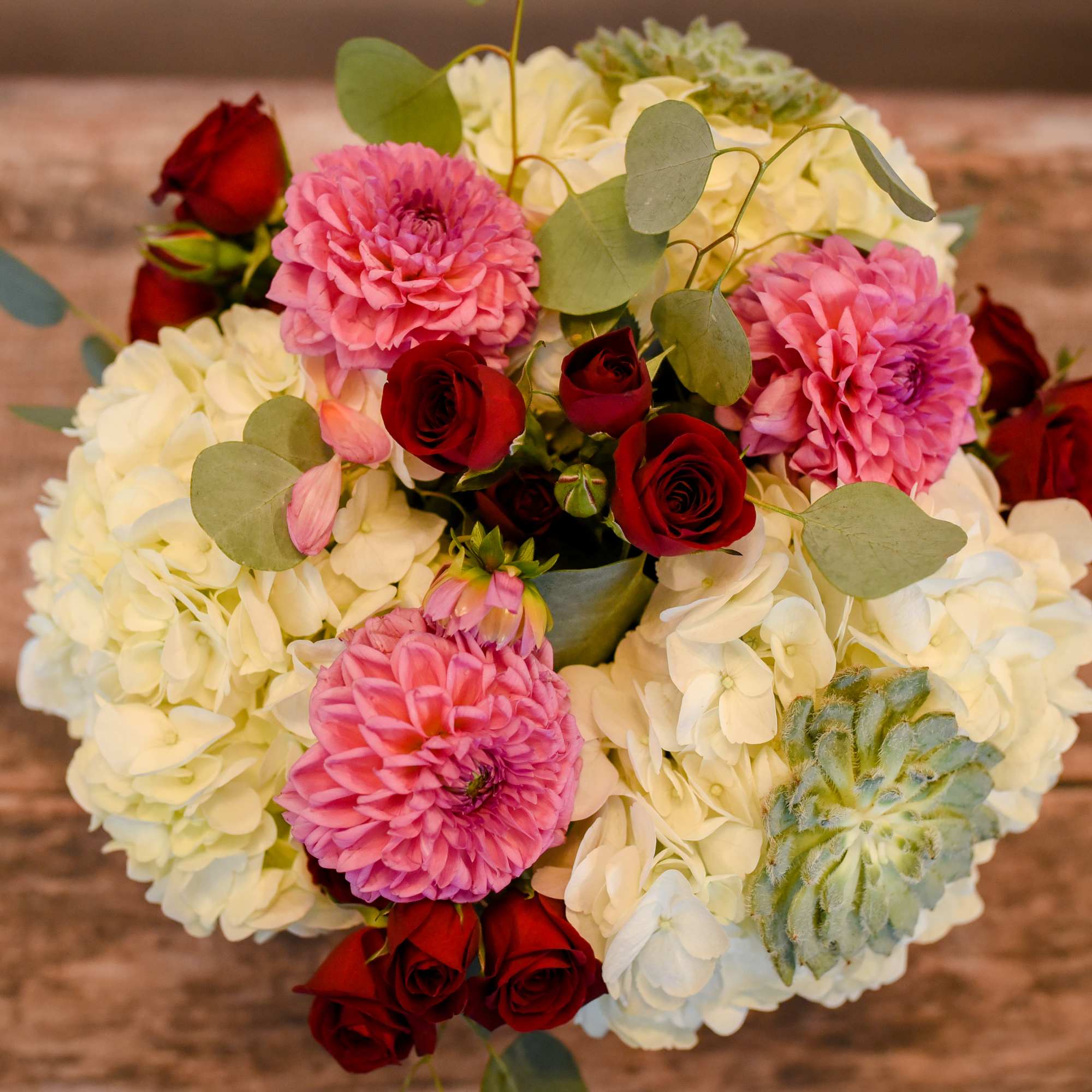 Bouquet of pink dahlias, red roses, and white hydrangeas with eucalyptus