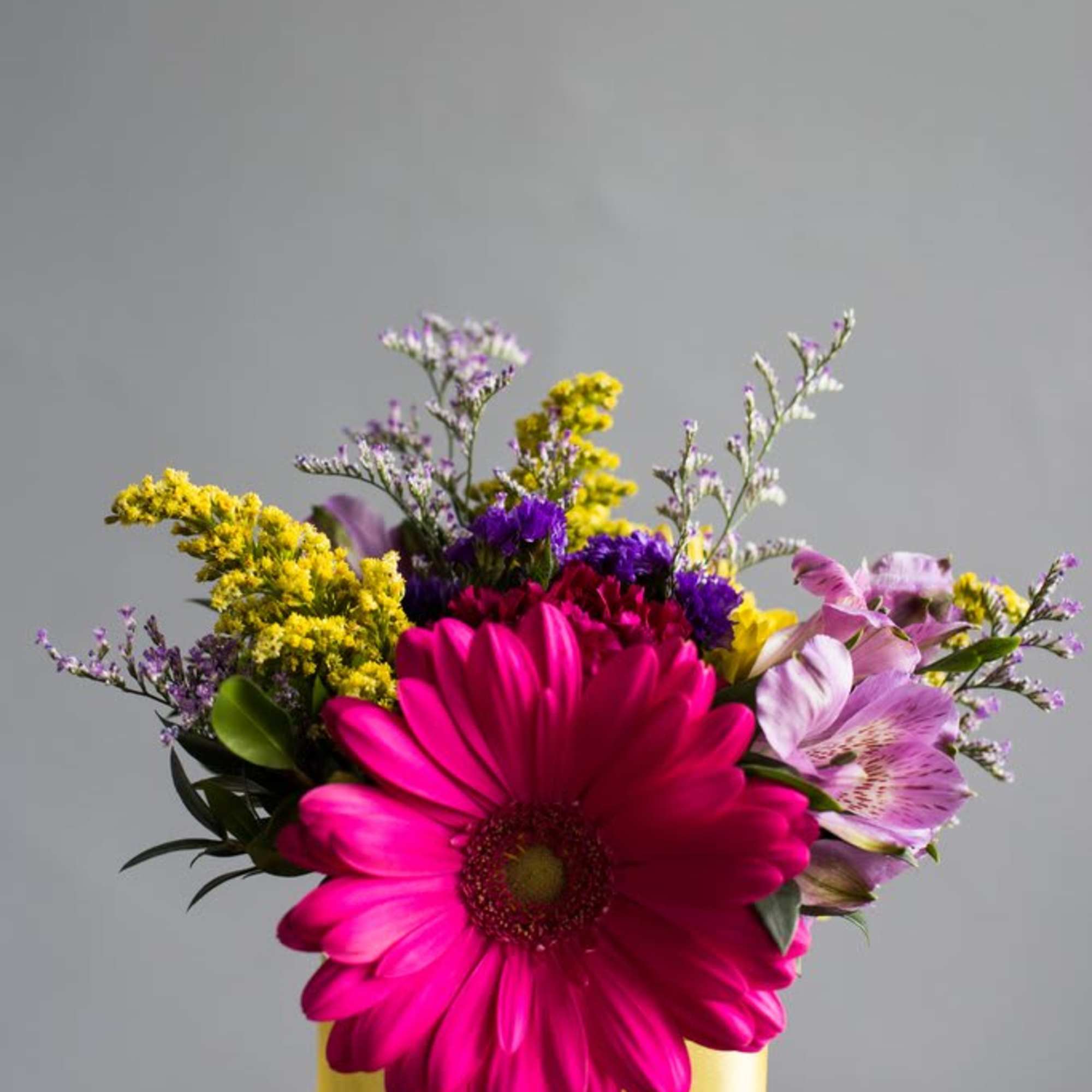 Bright arrangement featuring carnations, gerbers, alstromeria and more in a 4" glass