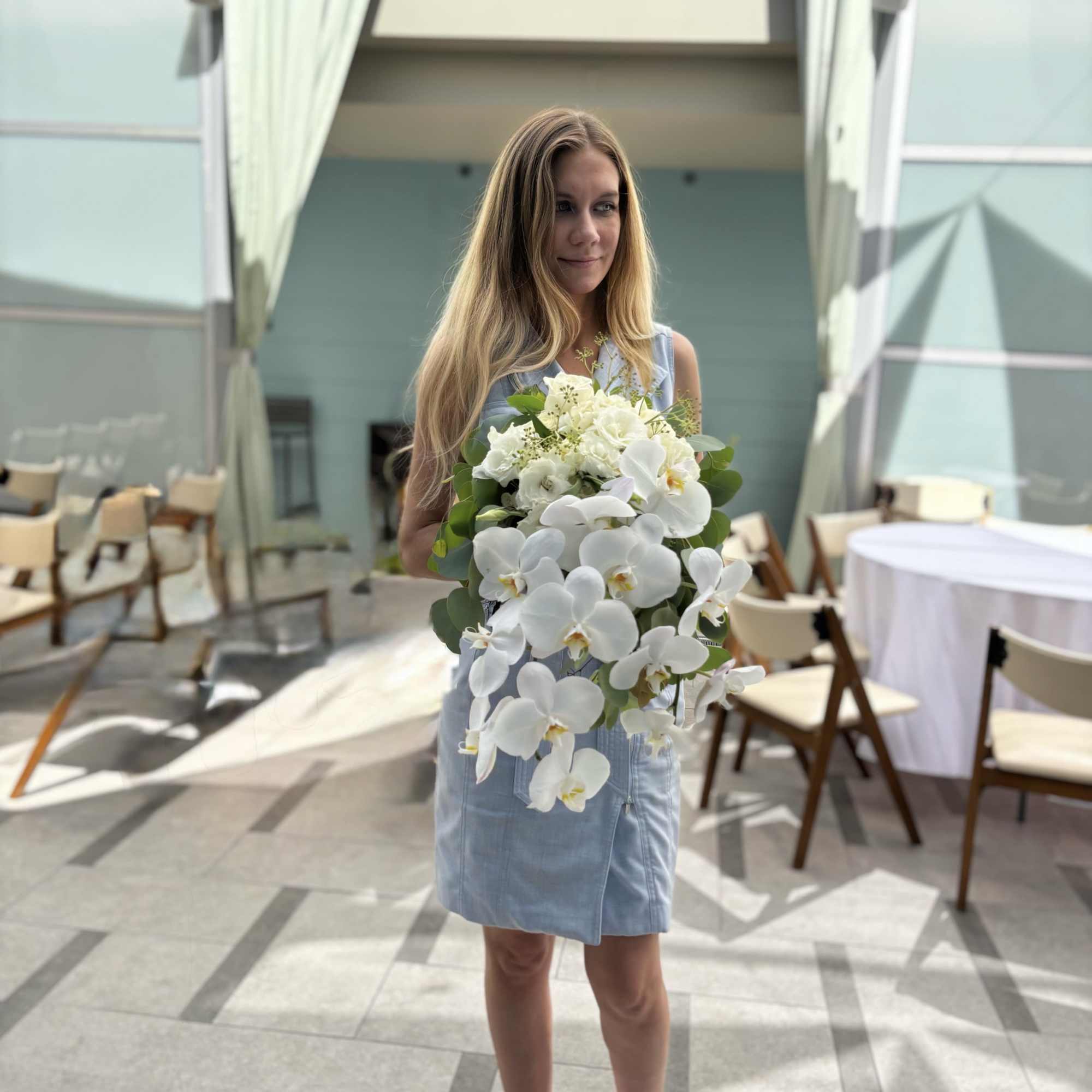 Woman holding a bouquet of white orchids and hydrangeas