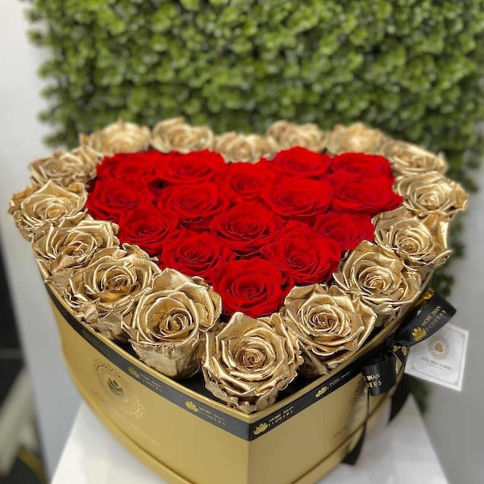 Heart-shaped gold box filled with red and gold roses