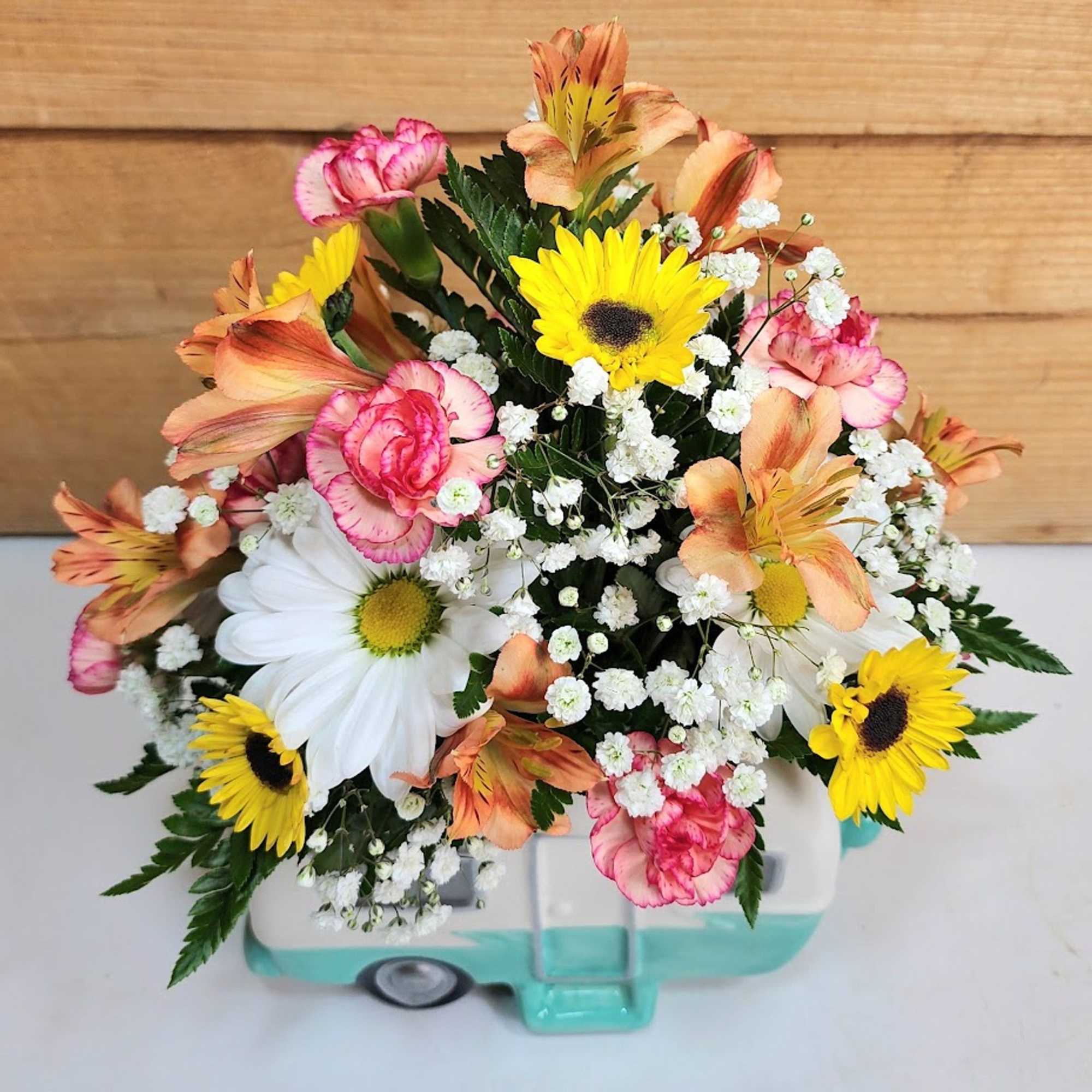 Mixed bouquet with daisies, carnations, and baby's breath in a small container