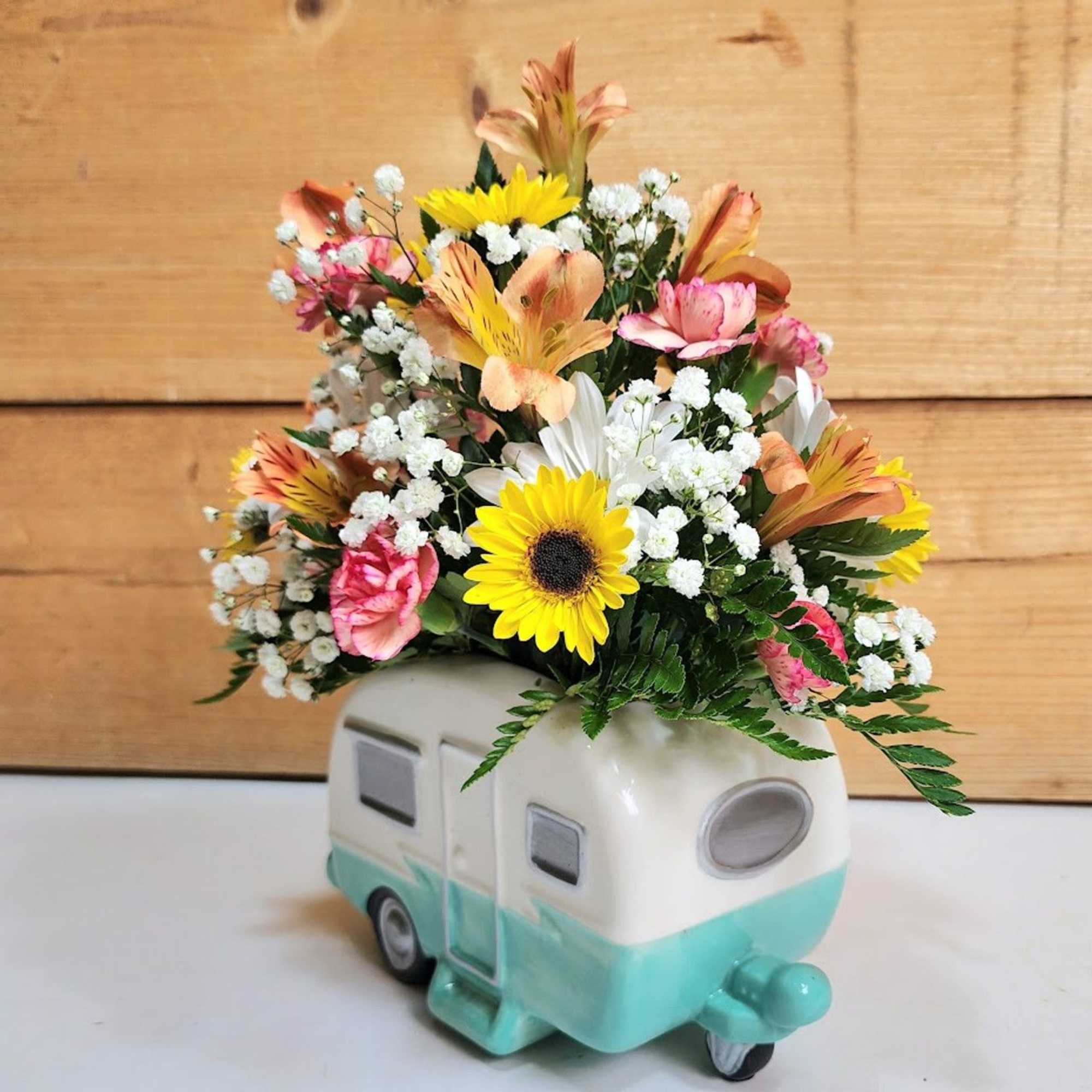 Mixed bouquet in a ceramic camper-shaped vase