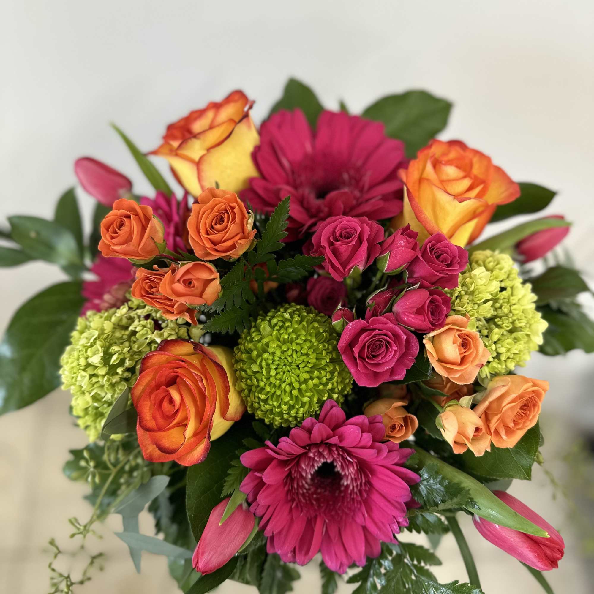 Bright mixed bouquet with orange and pink roses and magenta daisies