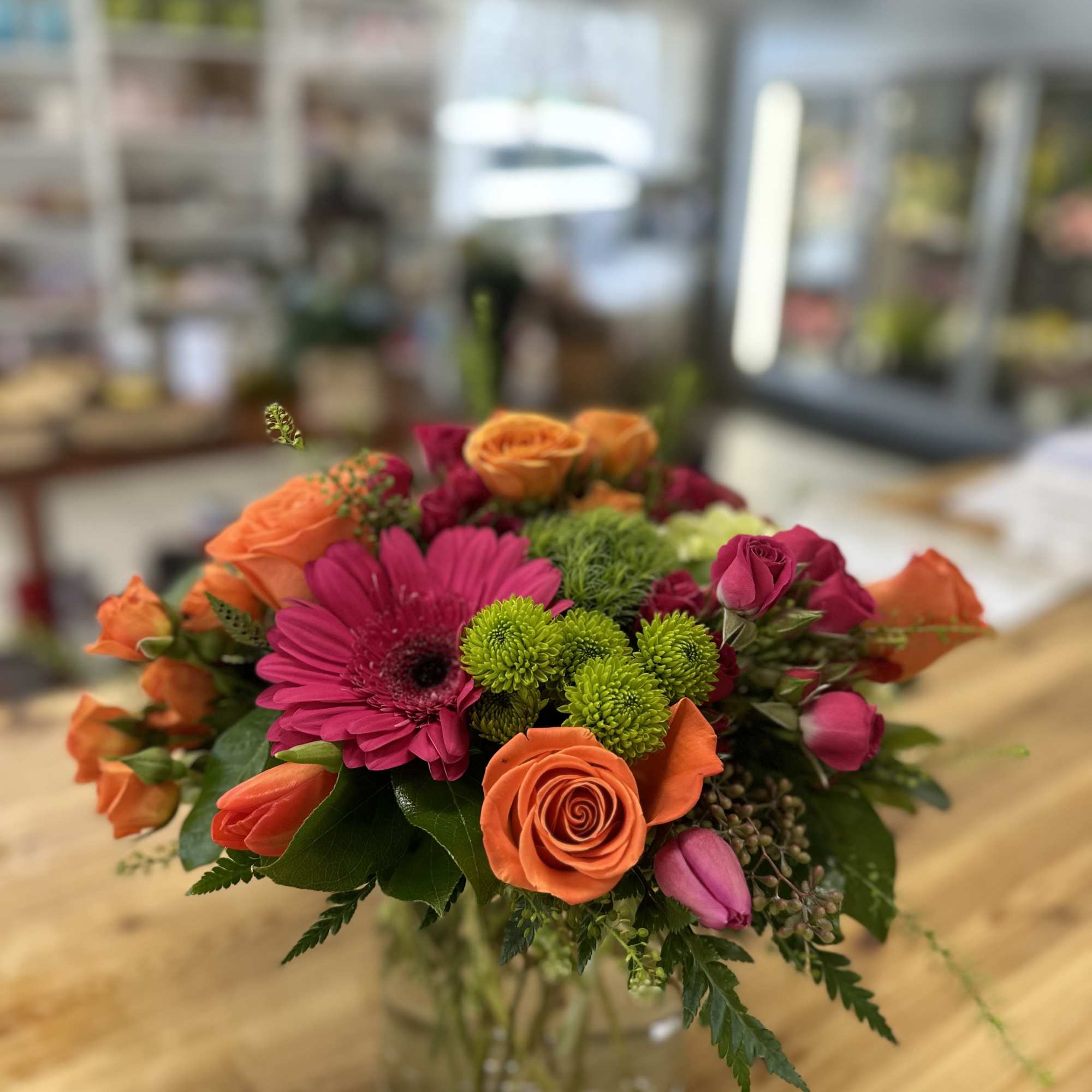 Bouquet of orange and pink flowers in a clear glass vase