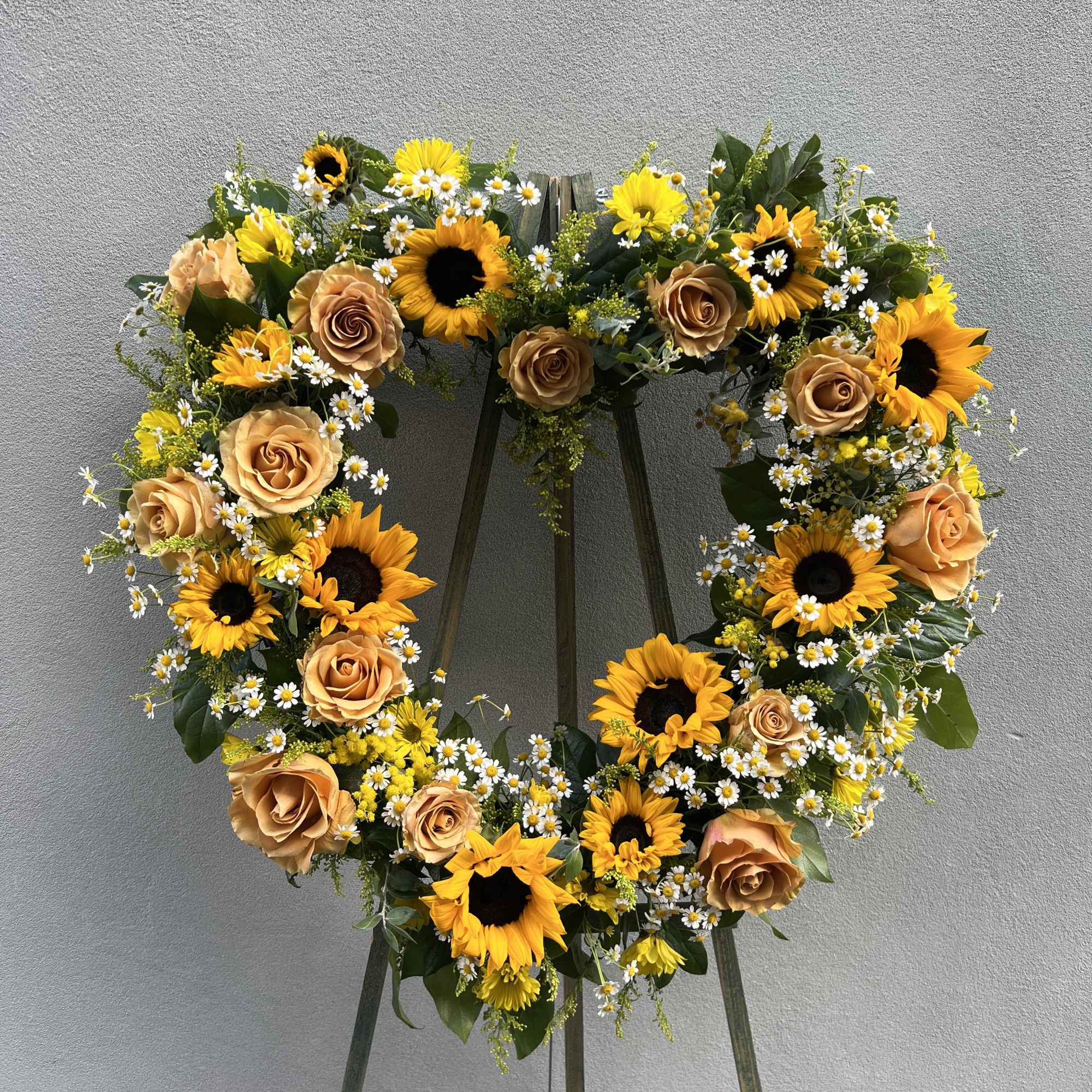Sunflowers, roses, solidado and seeded eucalyptus standing spray.