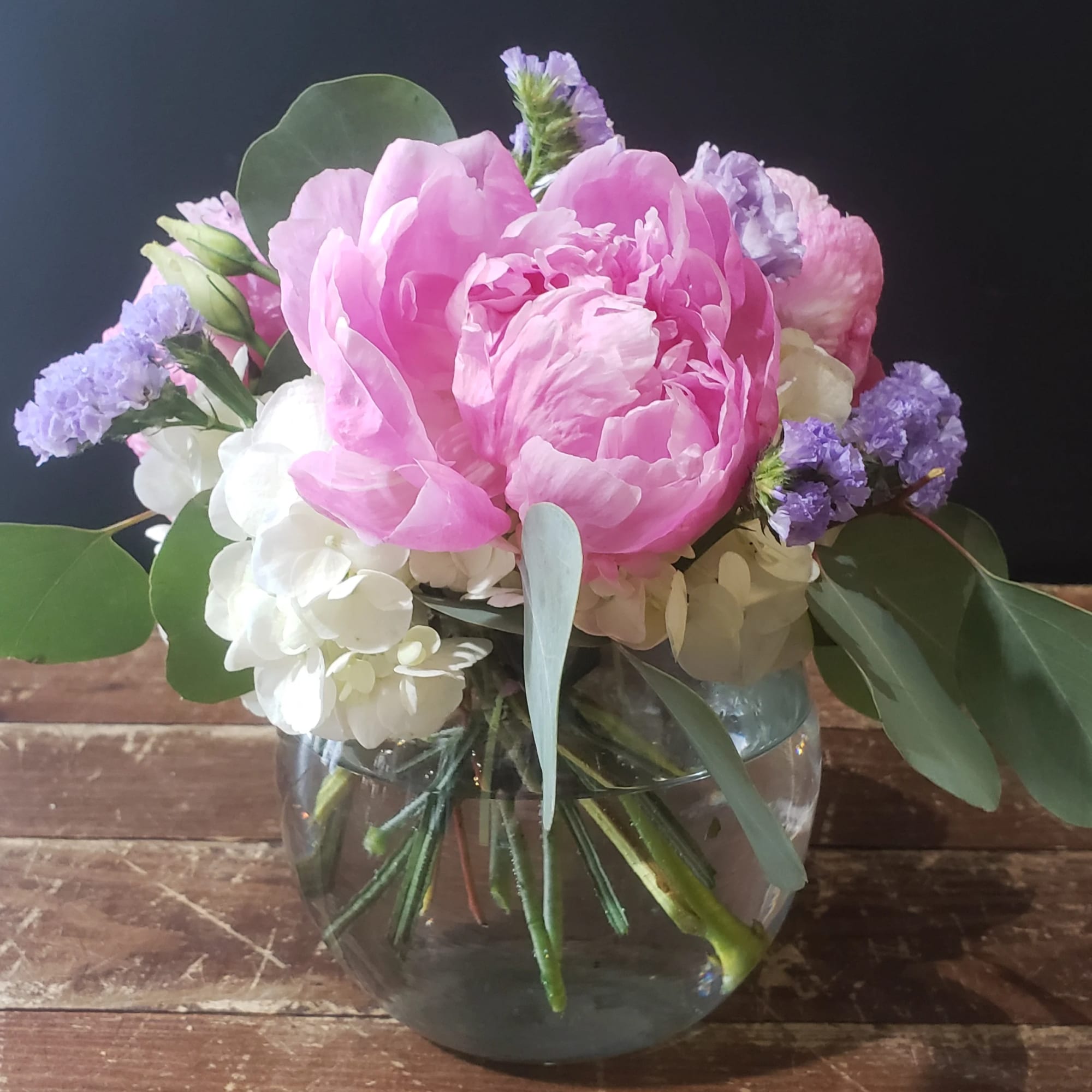 Pink peonies and white hydrangeas in a clear glass vase
