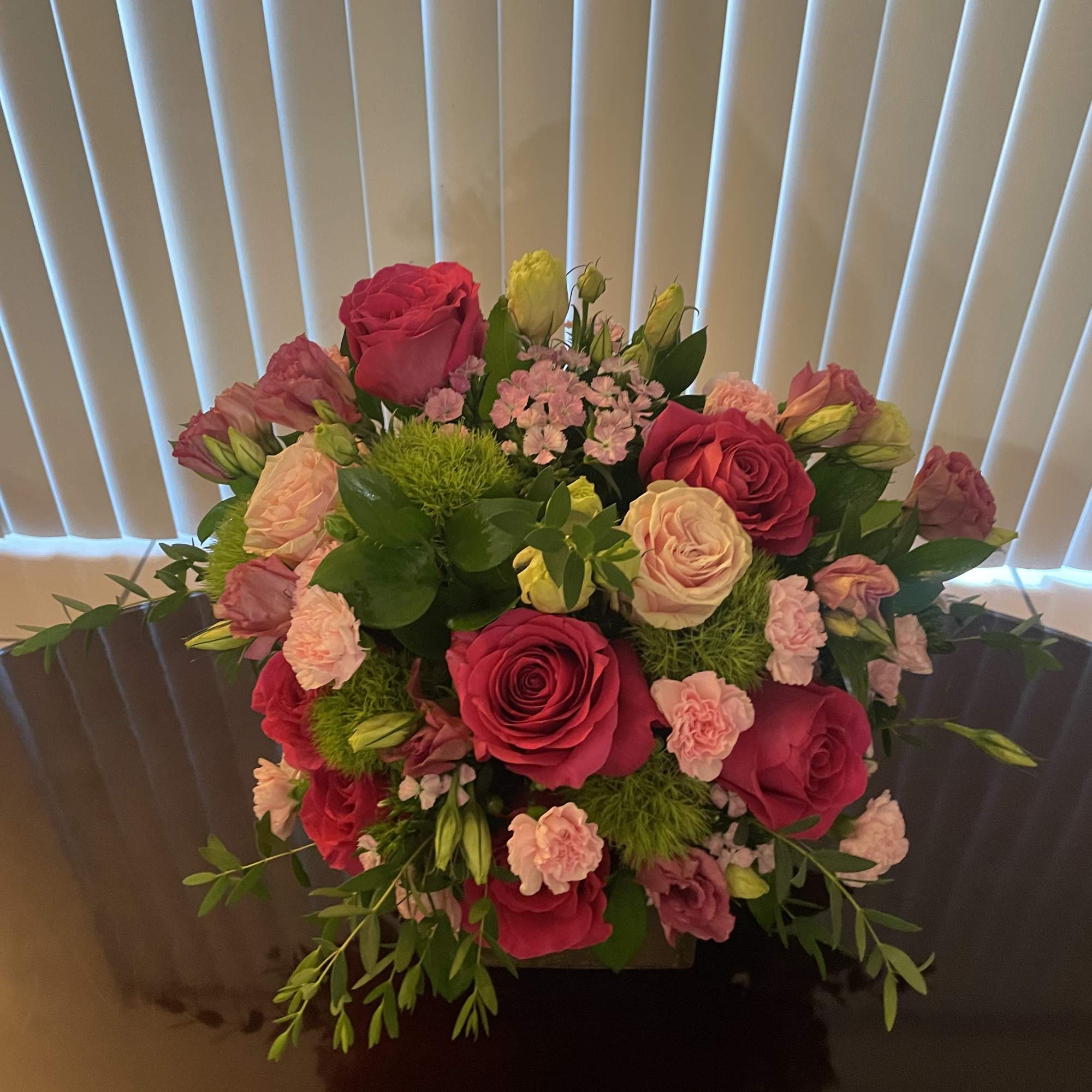Bouquet of pink and peach roses with small pink filler flowers