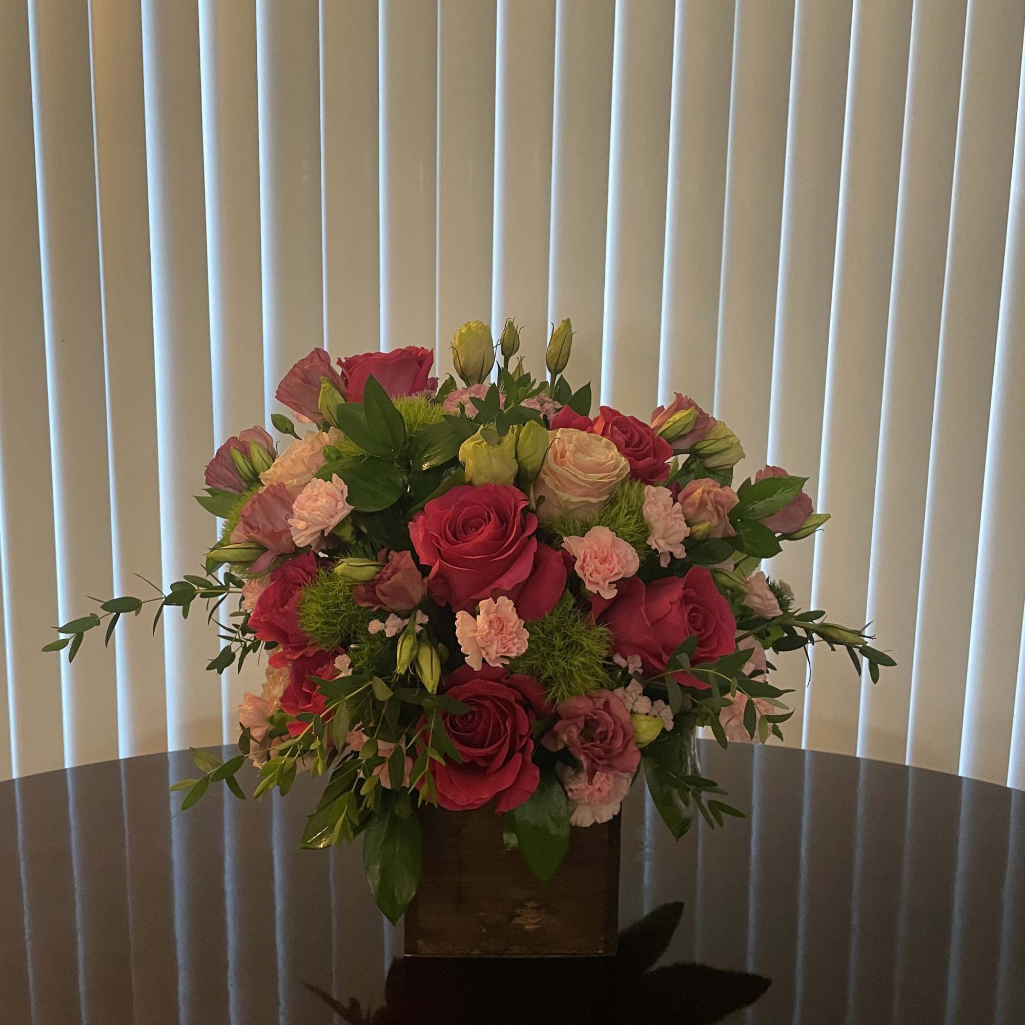 Pink and peach rose bouquet in a square vase