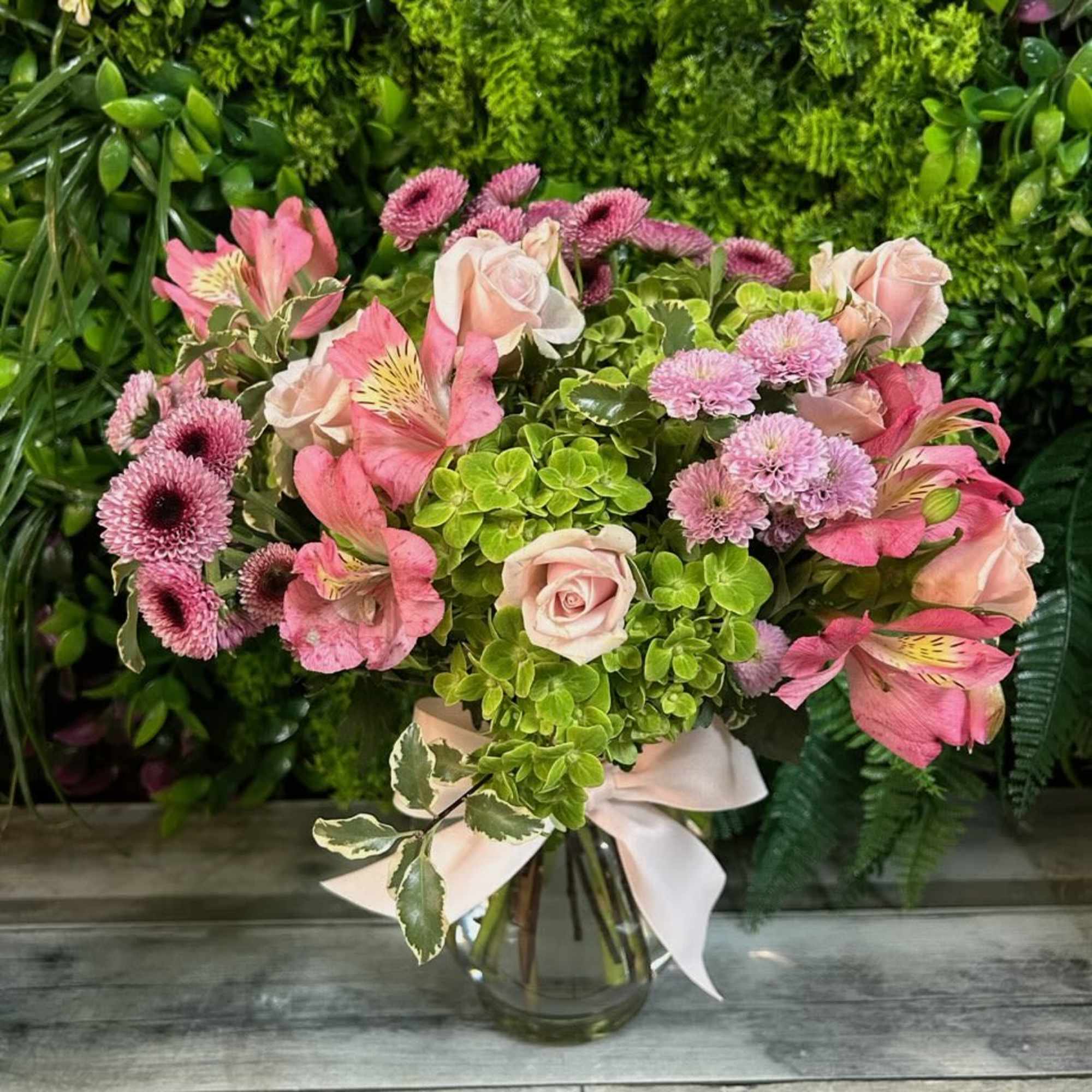 Pink bouquet with roses, alstroemeria, and chrysanthemums in a glass vase