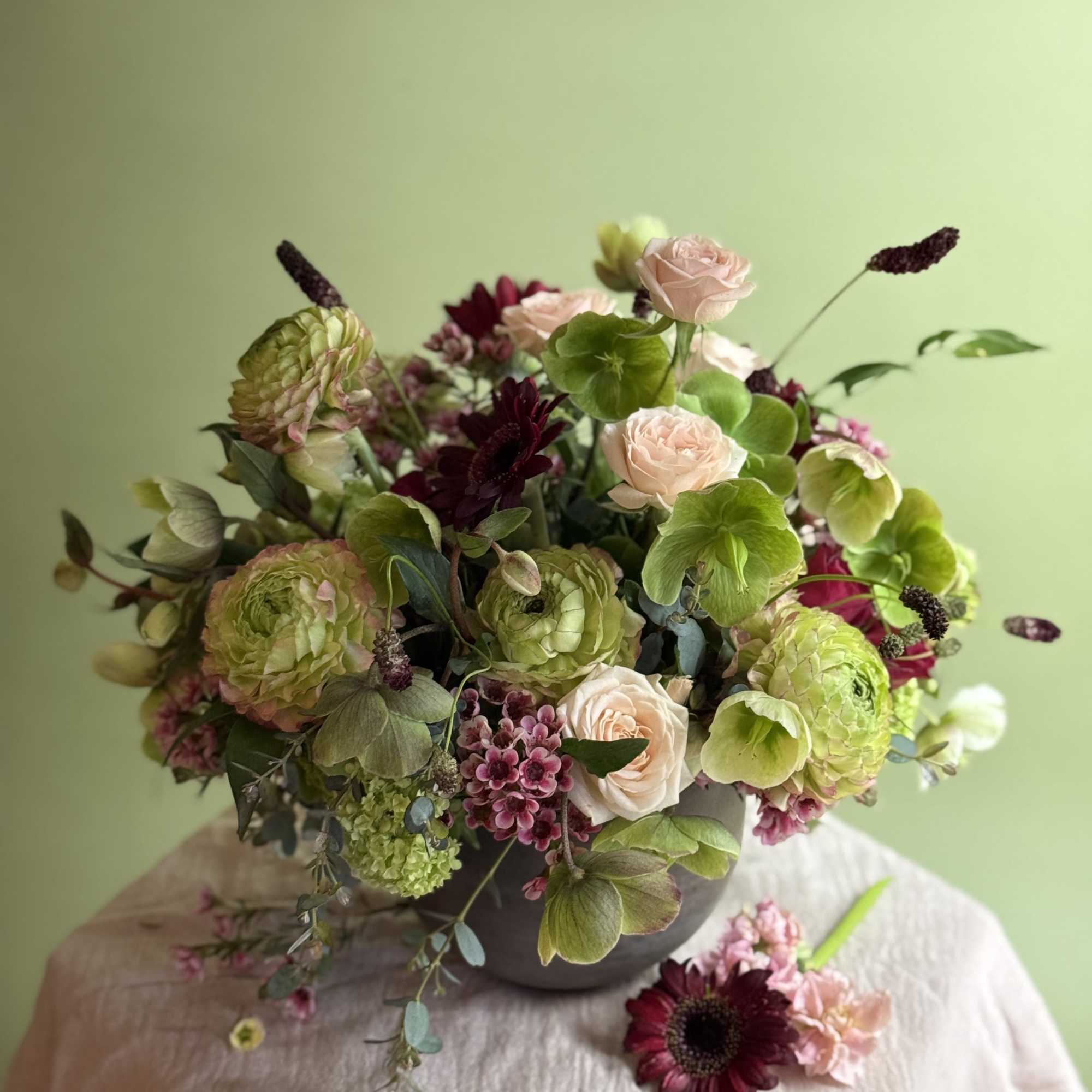 Mixed bouquet in a gray vase with pale pink roses and green blooms