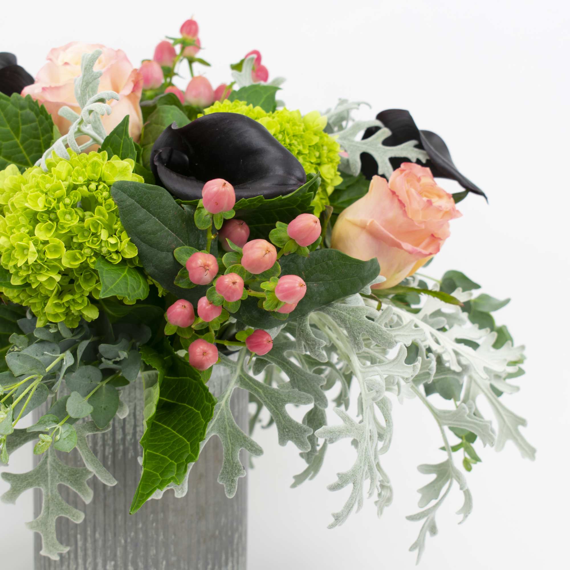 Peach roses and green hydrangeas in a gray vase