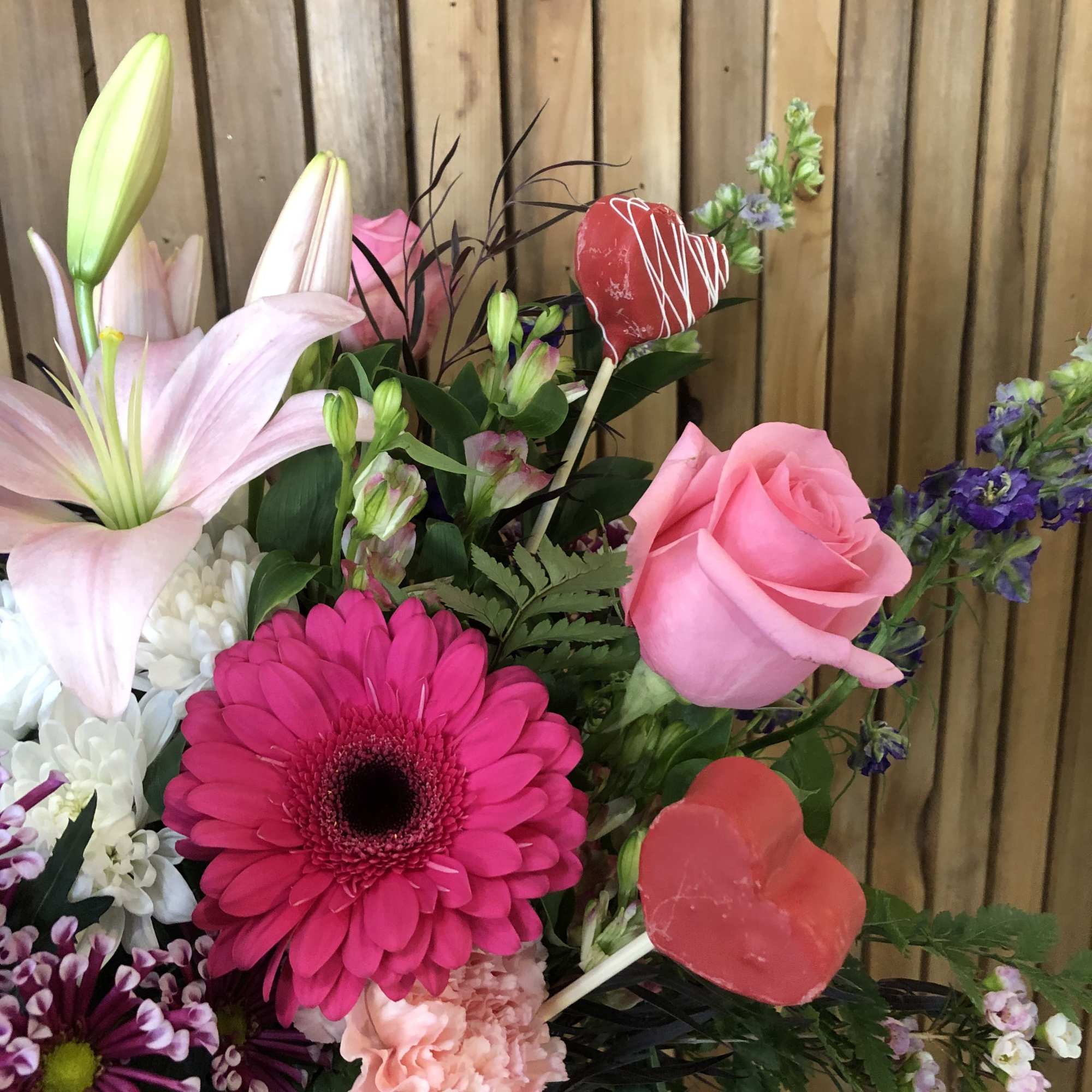 Mixed bouquet with pink lilies, roses, gerbera daisies, and lollipops