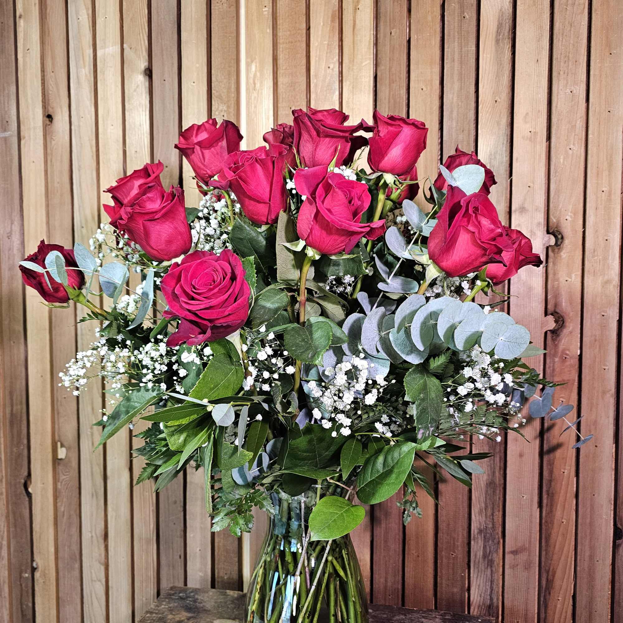 Pink rose bouquet in a glass vase with eucalyptus and baby's breath