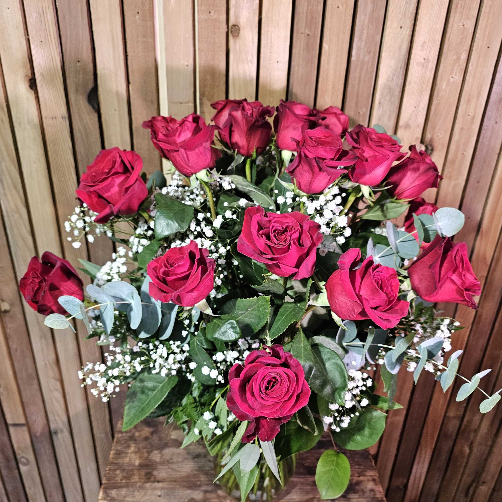 Bouquet of hot pink roses with baby's breath in a glass vase