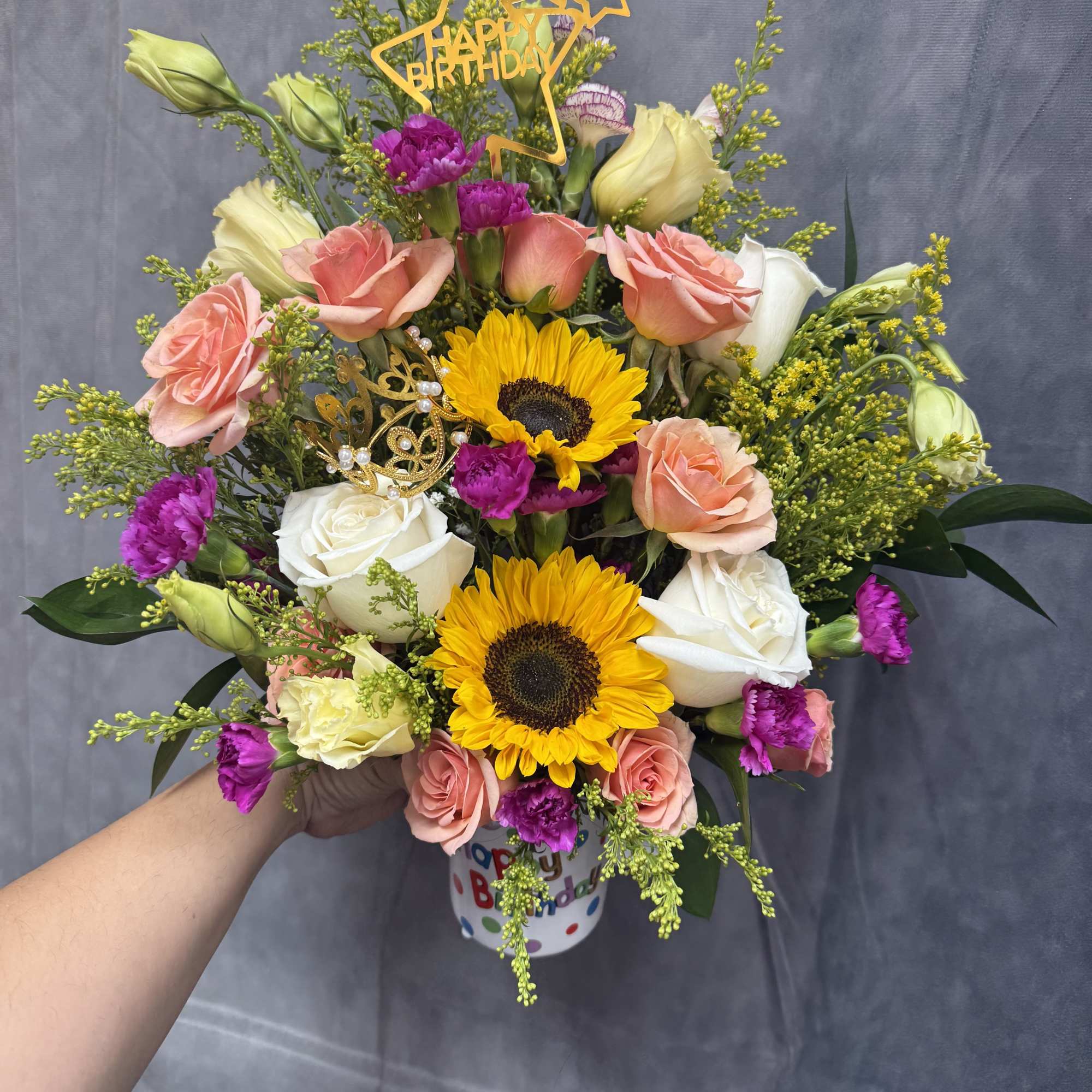 Birthday bouquet with sunflowers, roses, and a topper in a mug